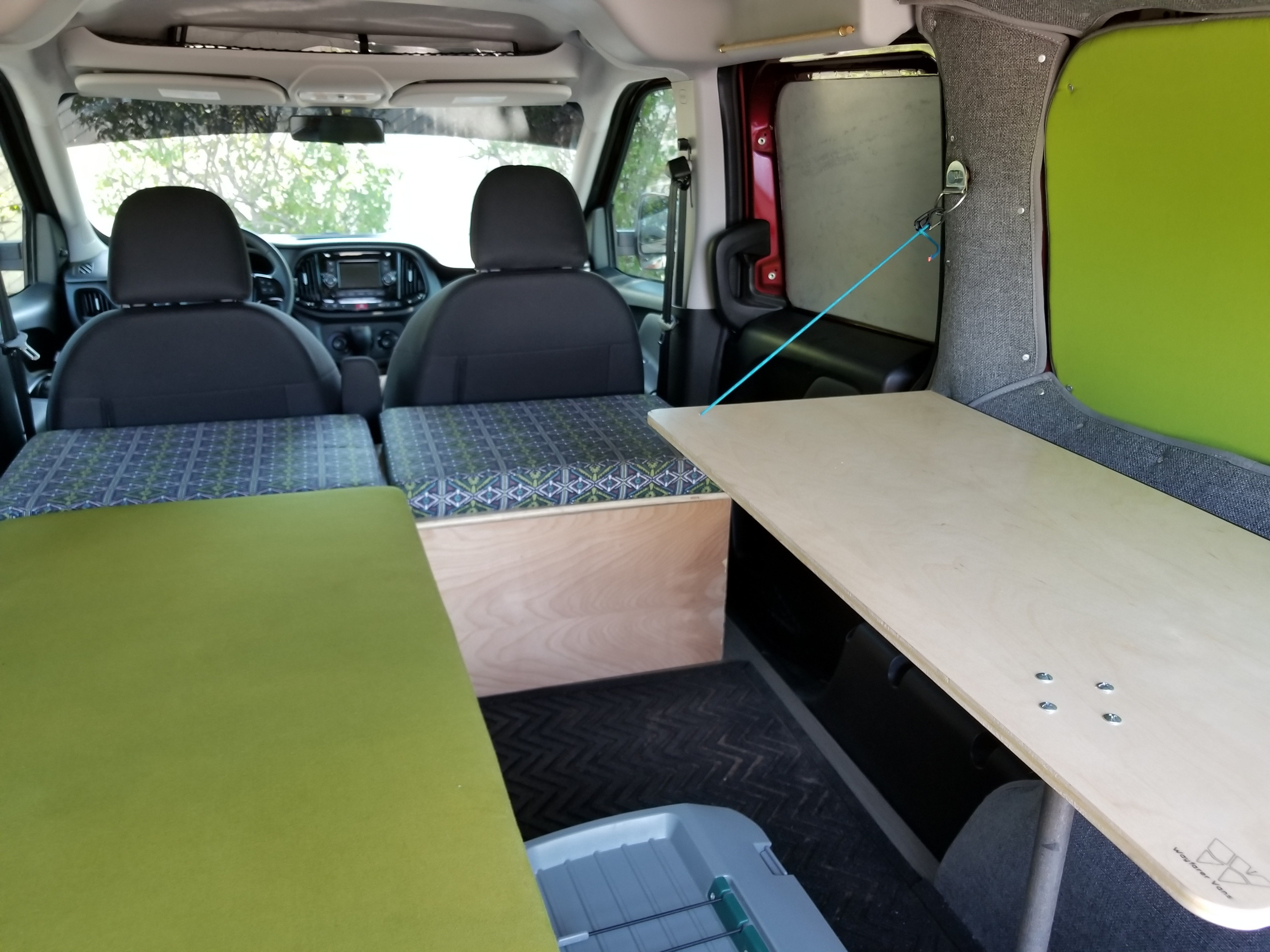 Step inside this RV rental! A well-appointed camper van interior with comfy beds, patterned cushions, and a functional side table.. Ram ProMaster City 2017
