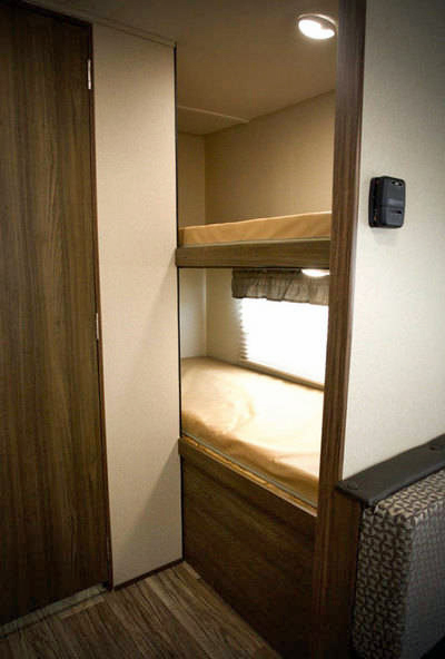Compact RV rental interior featuring cozy bunk beds with mattresses, a window, and a thermostat for comfortable sleeping.. Riverside Rv Dream 175BH 2018