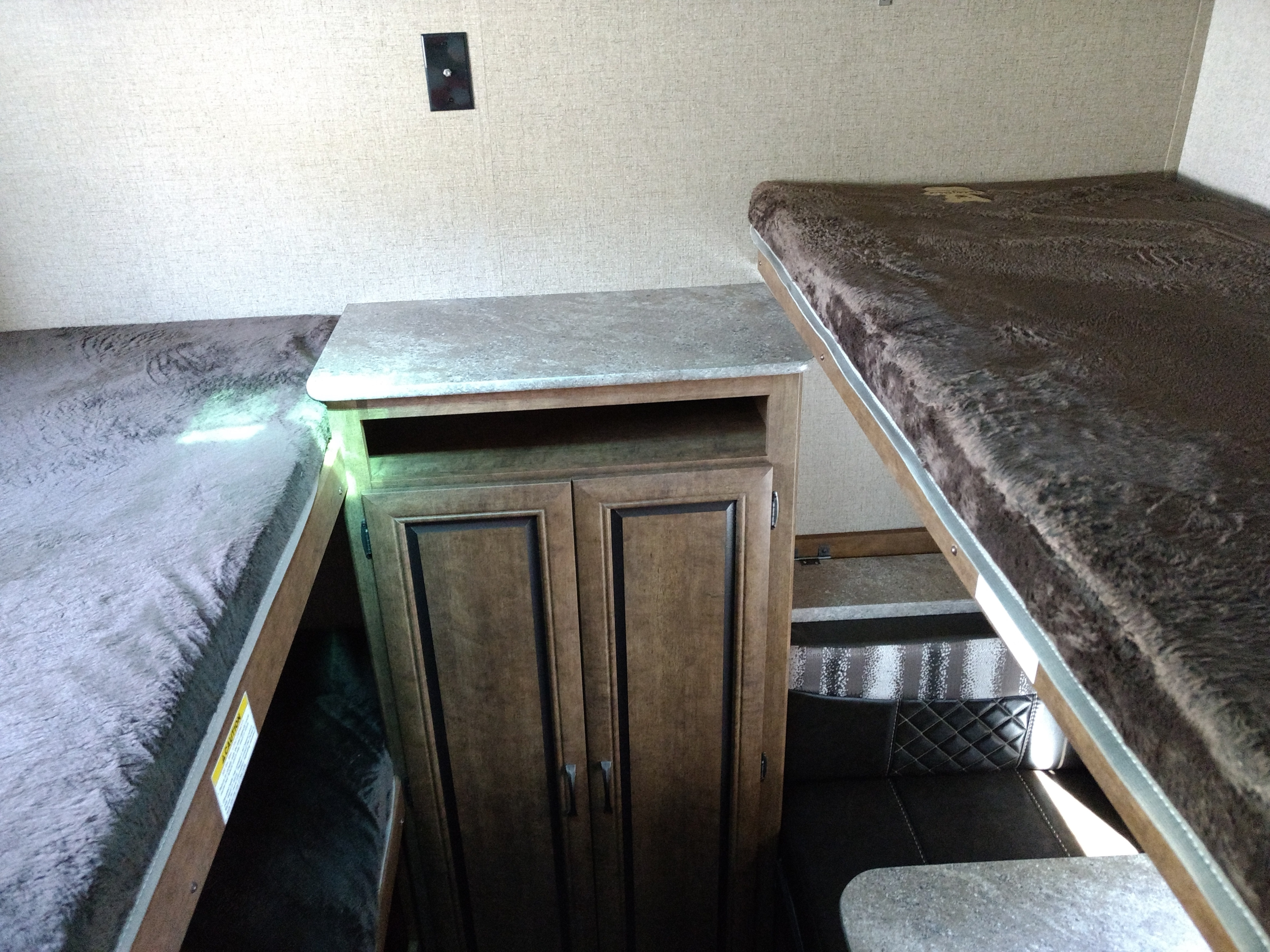 RV rental: comfy bunk beds, central storage cabinet, and dinette seating in camper interior.. Crossroads Zinger 2018