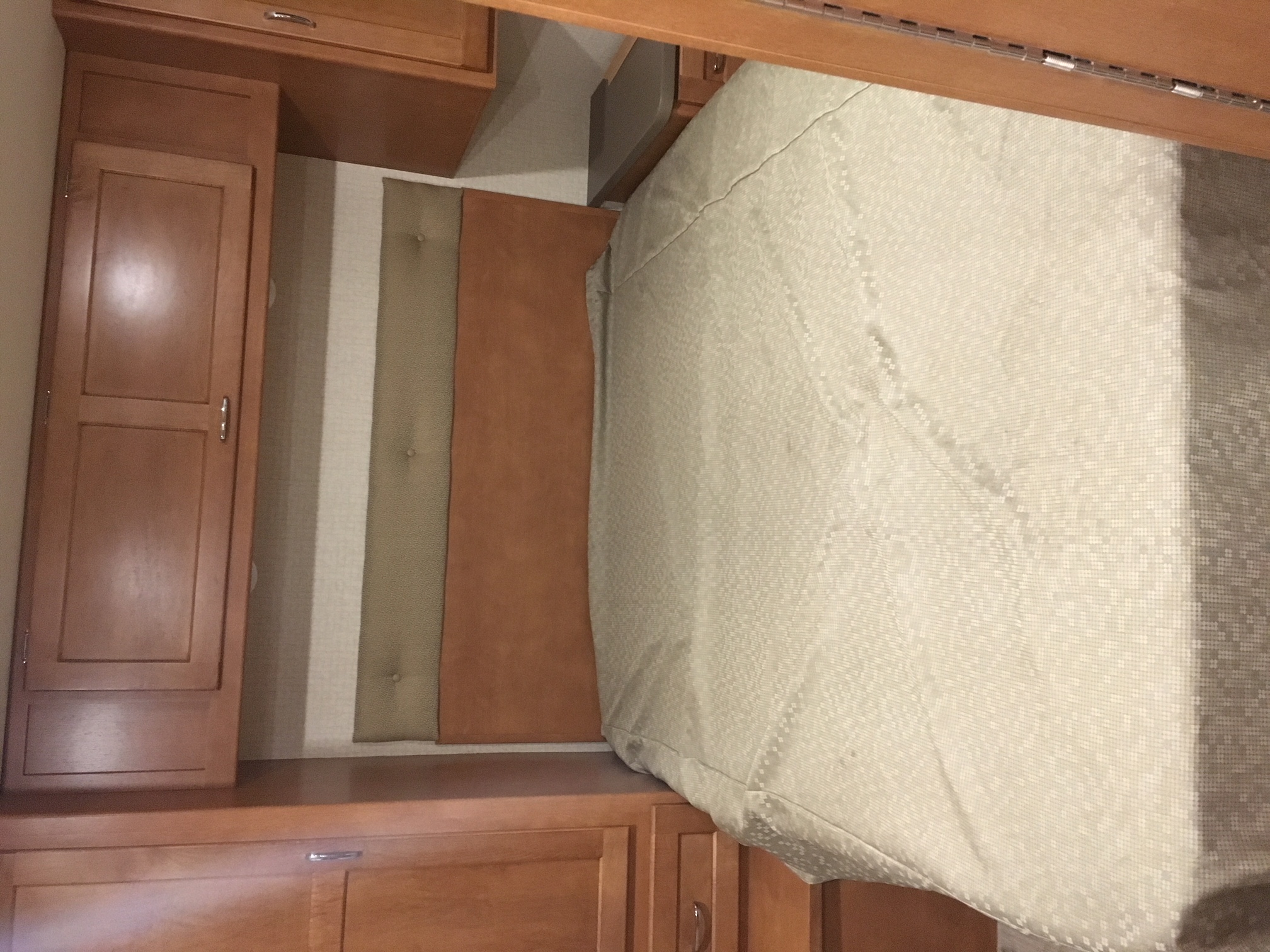 Cozy RV rental bedroom with comfortable bed and built-in wooden cabinetry for storage.. Winnebago Minnie Winnie 2017