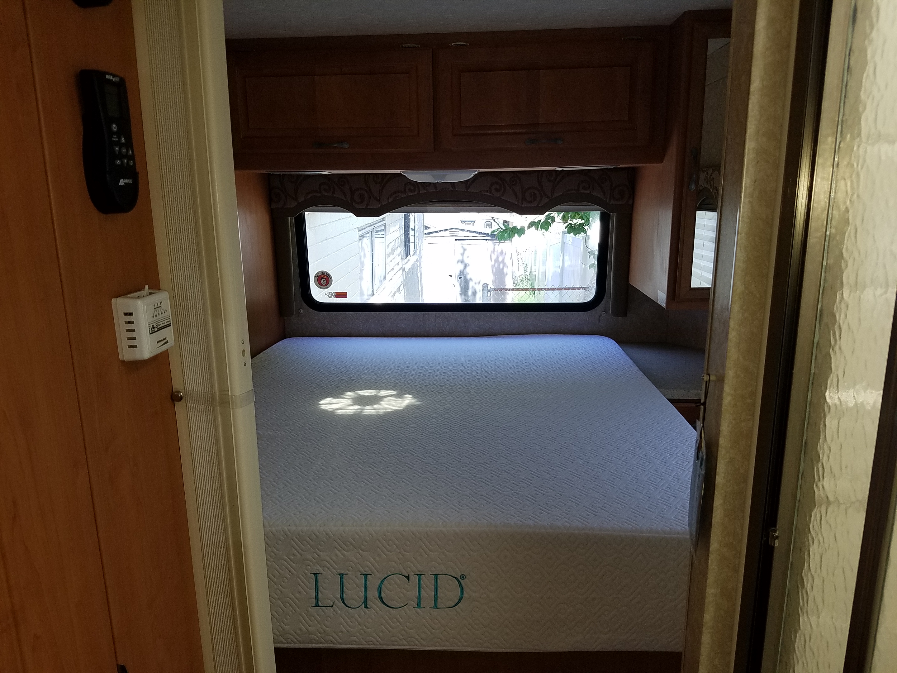 Experience comfort in this RV rental bedroom: a Lucid mattress, climate controls, and window views.. Four Winds Chateau Sport 2008
