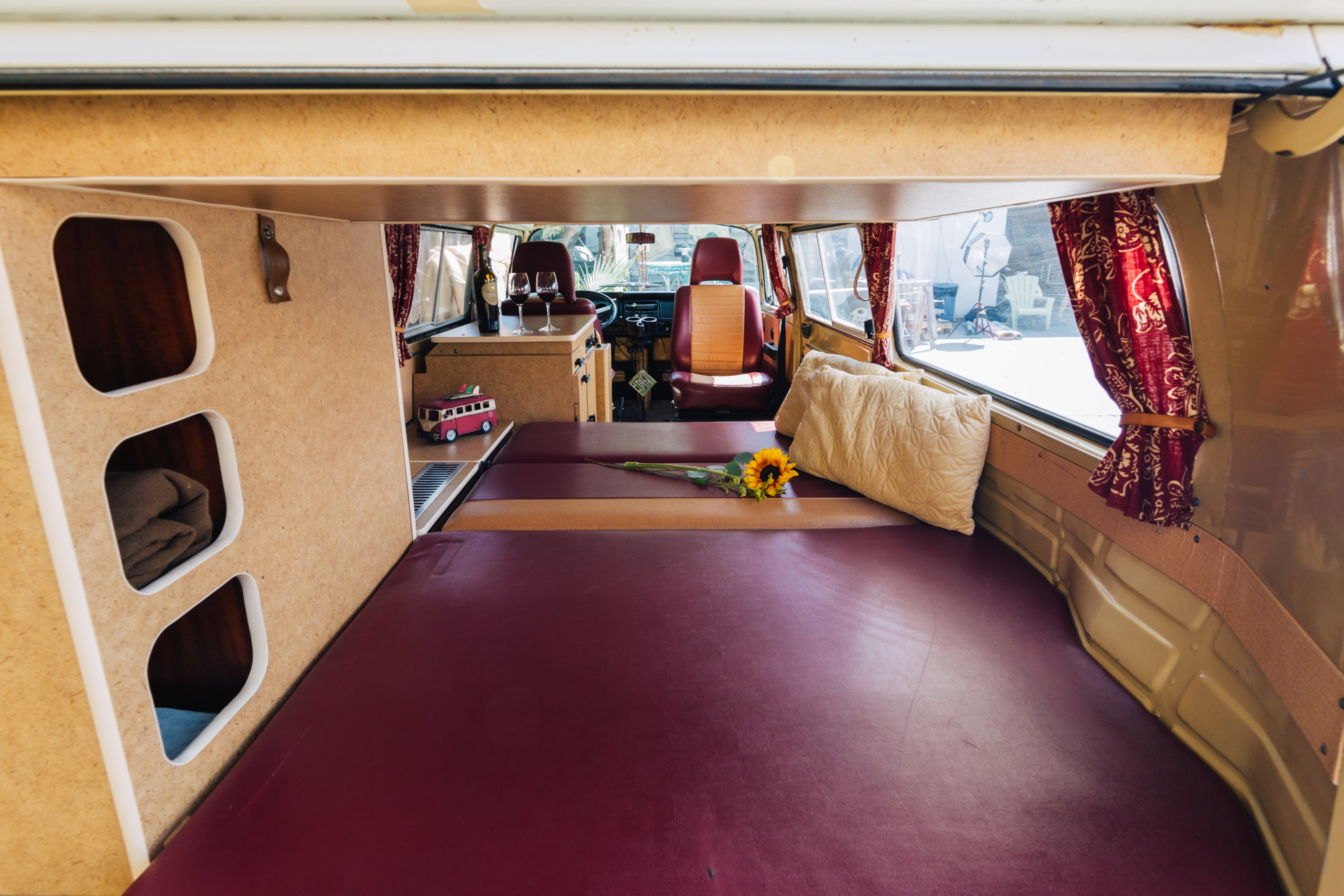 This RV rental offers a cozy interior with a spacious bed, built-in storage, and a small counter for drinks.. Volkswagen Westfalia 1978