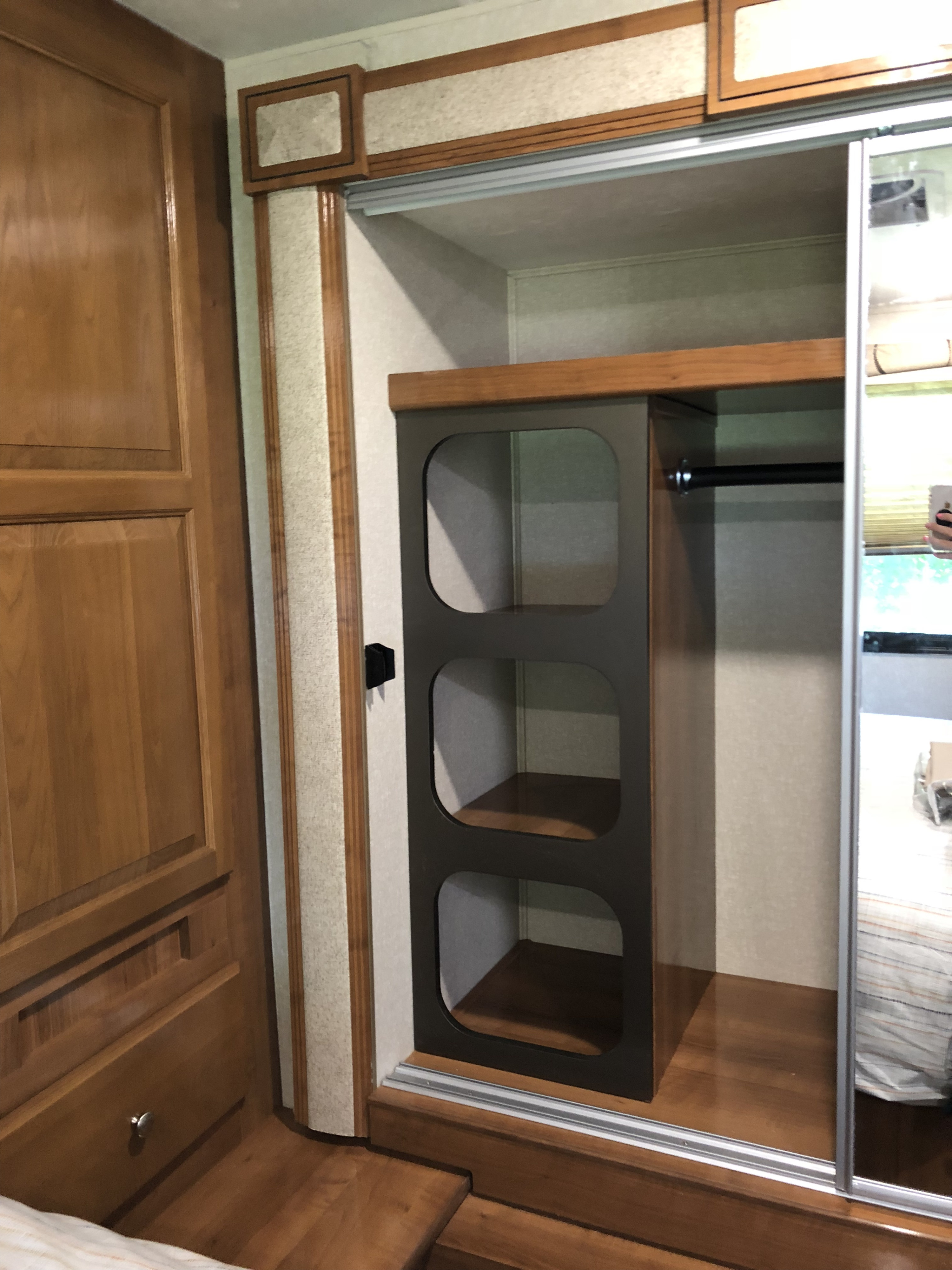 RV rental interior: A functional closet with built-in shelving, hanging rod, and mirrored sliding doors for storage.. Forest River Coachmen Leprechaun 2019