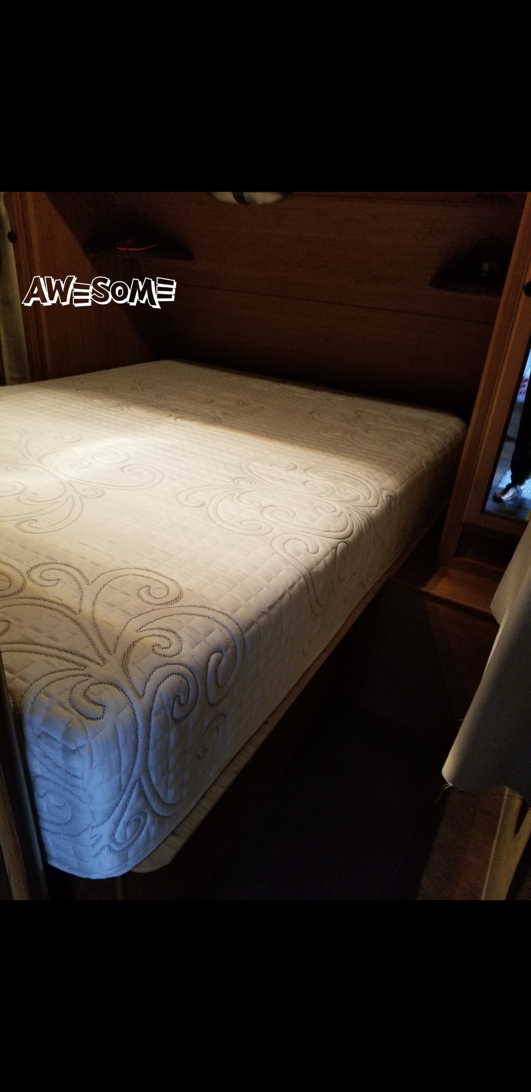 Awesome RV rental: A cozy sleeping area featuring a patterned mattress on a wooden bed frame, with a mirror reflecting a person.. Crossroads Sunset Trail 2015