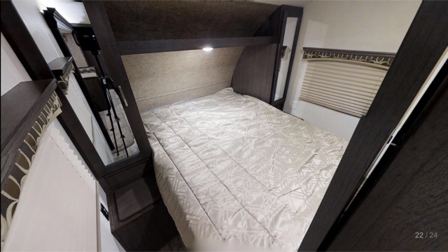 Cozy RV rental bedroom features a queen bed with light bedding, overhead storage, and window blinds. Ideal for travel.. Forest River sonoma 2018