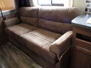 Cozy brown sofa inside an RV rental, perfect for relaxing in your camper's living area on laminate flooring.. Jayco Jay Feather 2017
