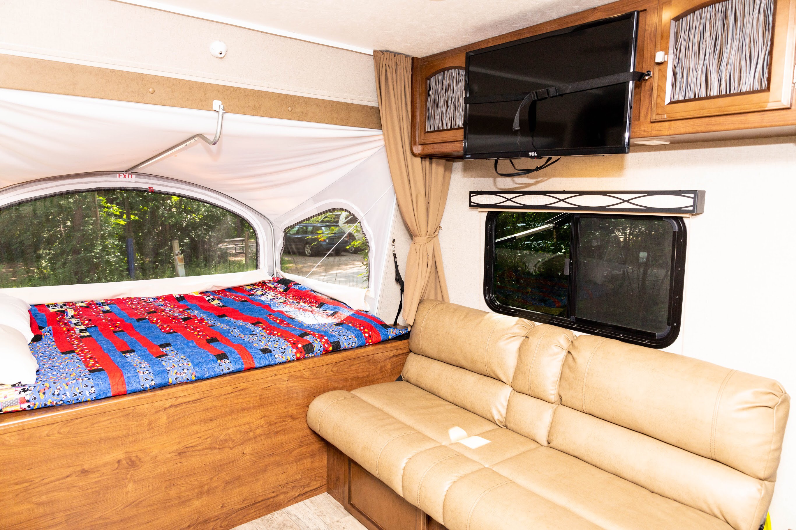 Spacious RV rental with a comfy bed, colorful blanket, TV, and sofa.. Coachmen Freedom Express 2018
