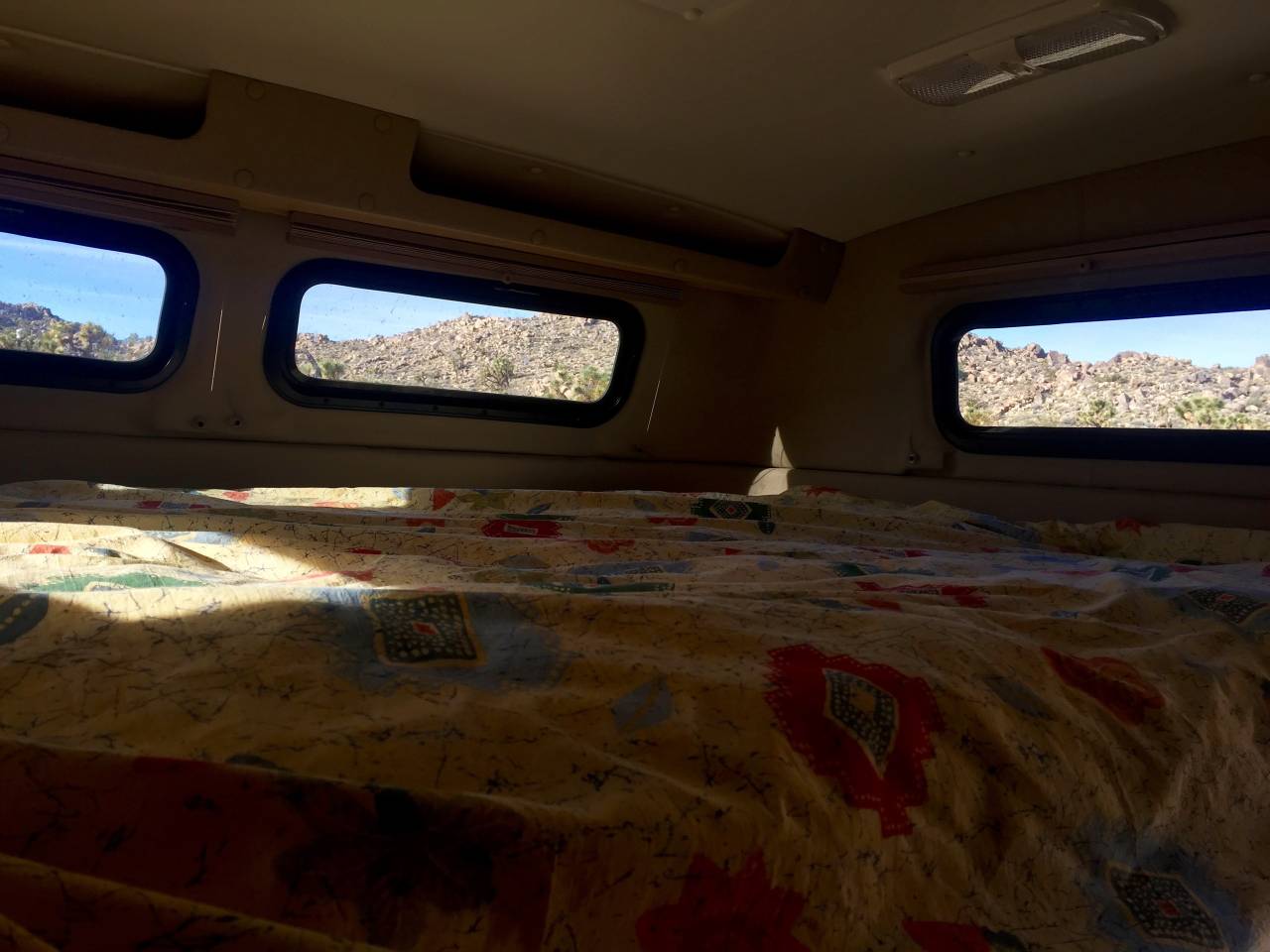 Cozy RV rental interior with a comfy bed and scenic desert mountain views through the windows, perfect for travel.. Tiger Adventure Vehicle Bengal 2016