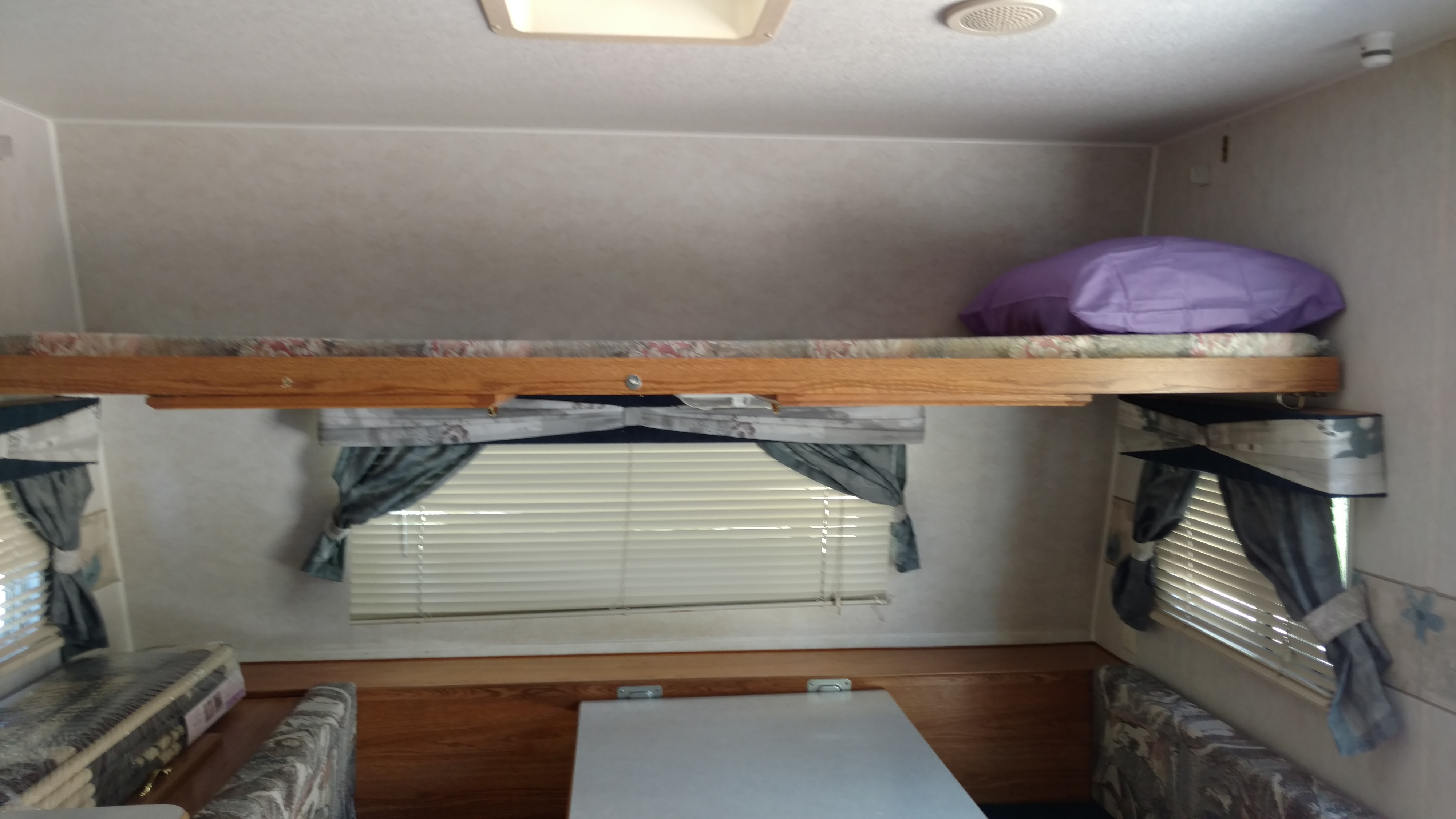 Cozy RV rental interior features a bunk bed, seating, and windows with blinds. Ready for your next adventure.. Fleetwood Prowler 2002