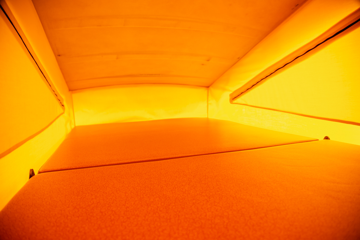 Explore comfortably in this RV rental's pop-top sleeping area, featuring an orange bed and yellow fabric walls.. Volkswagen westfalia 1979