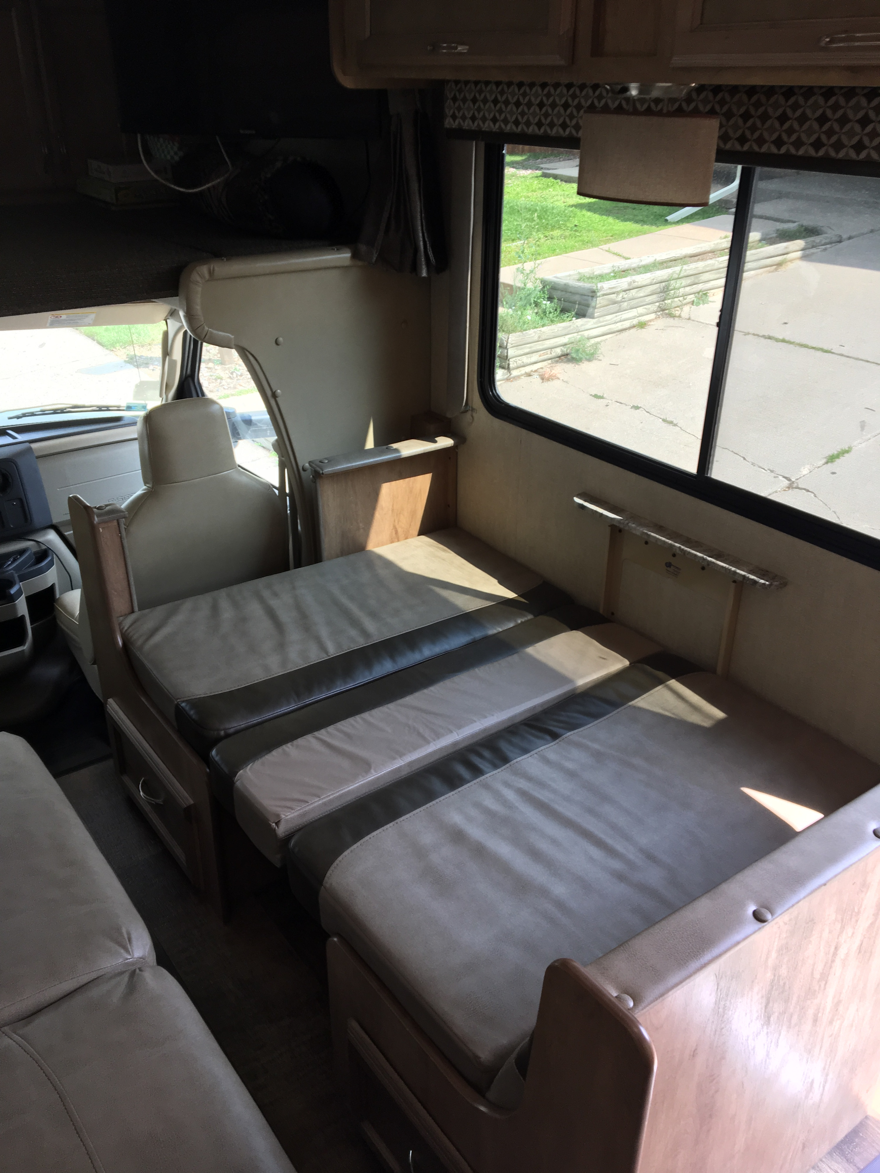 Spacious RV rental interior with a convertible dinette transformed into a cozy bed, offering comfortable seating and sleeping.. Gulf Stream Conquest 2018
