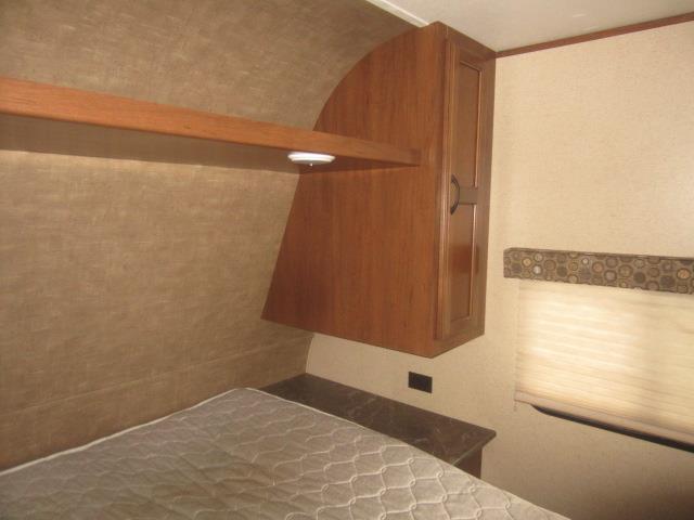 RV rental bedroom interior: bed, overhead shelf light, wooden cabinet, and window with blind.. Jay Flight 287 BHSW 2016