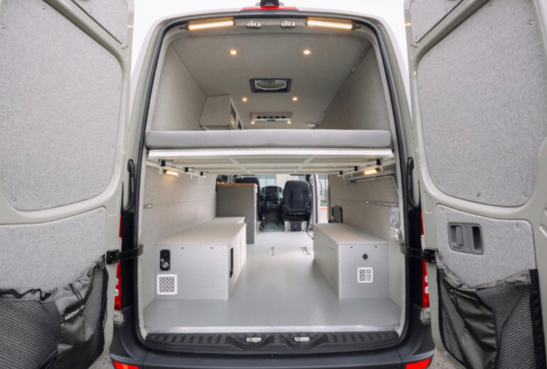 RV rental van conversion: open rear view showing elevated bed, storage boxes, and well-lit interior.. Mercedes-Benz Sprinter RV Motorhome Campervan 2018