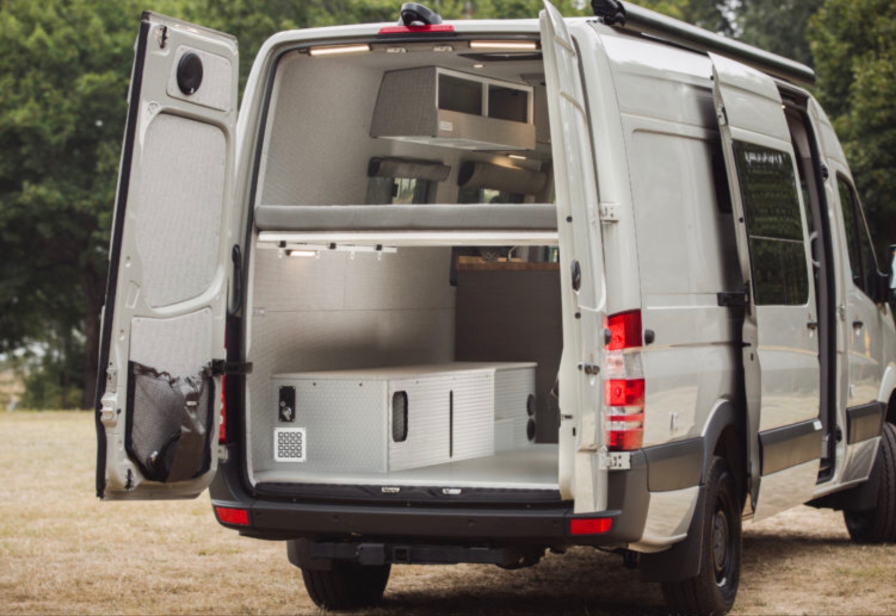 Customized RV rental camper van with open rear doors reveals its interior, including a bunk bed & ample storage.. Mercedes-Benz Sprinter RV Motorhome Campervan 2018