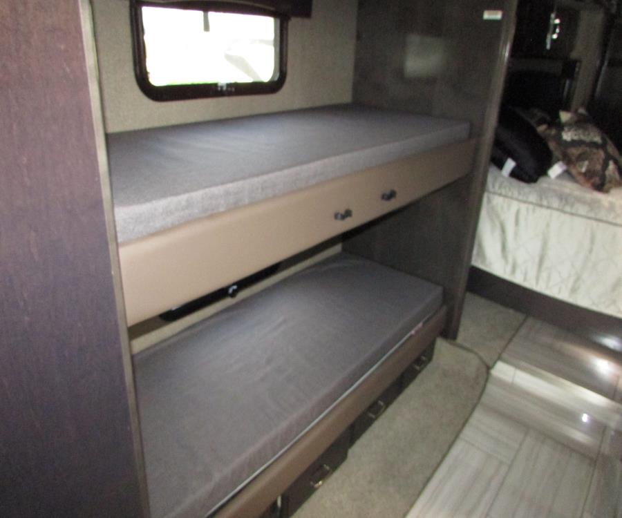 RV rental interior features comfortable bunk beds with grey mattresses, providing extra sleeping space and a view from the top bunk's window.. American Coach American Dream 2019