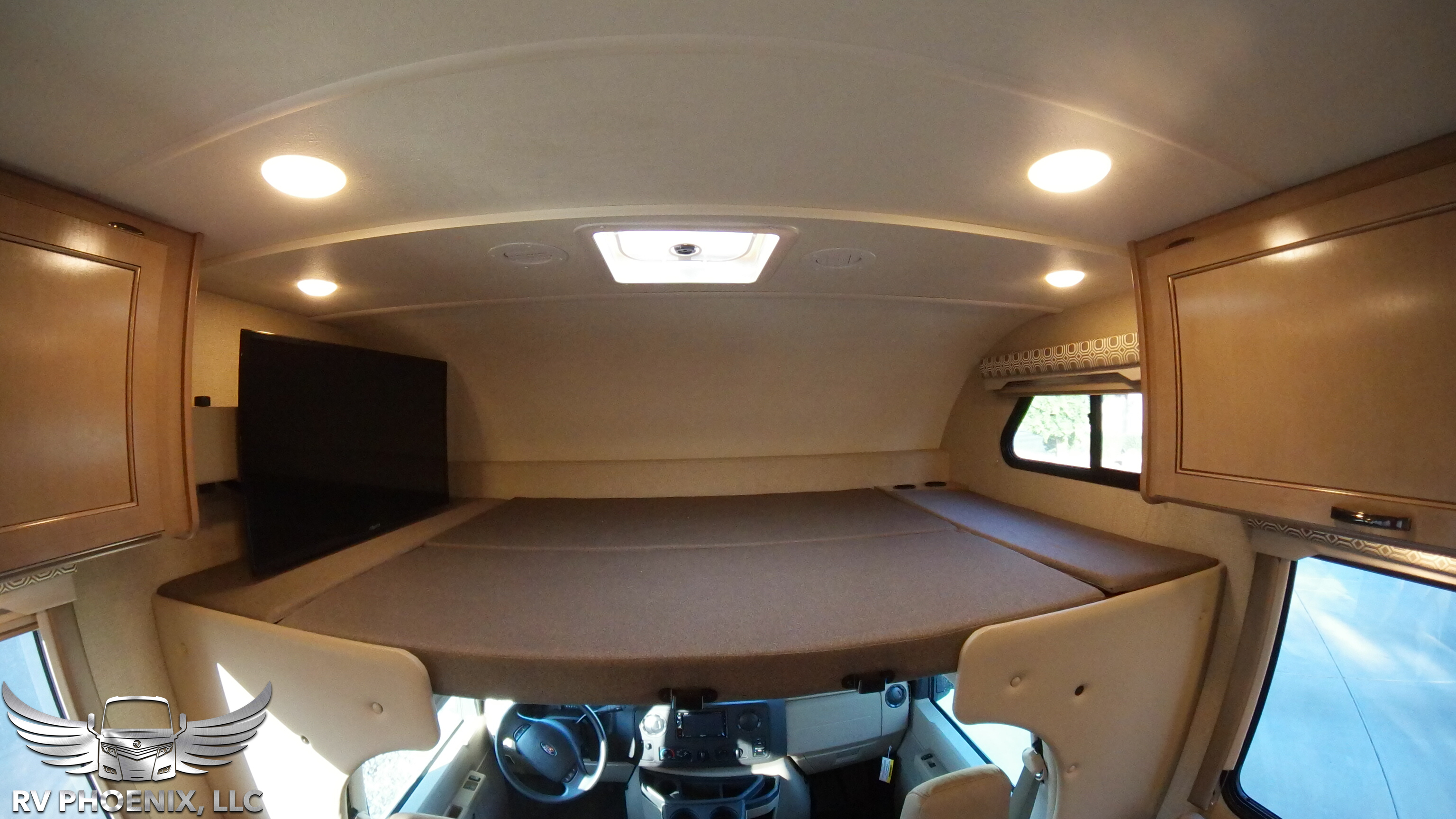 Inside this RV rental: view of the large cab-over bunk bed, front cockpit, and TV.. Thor Motor Coach Four Winds 2019