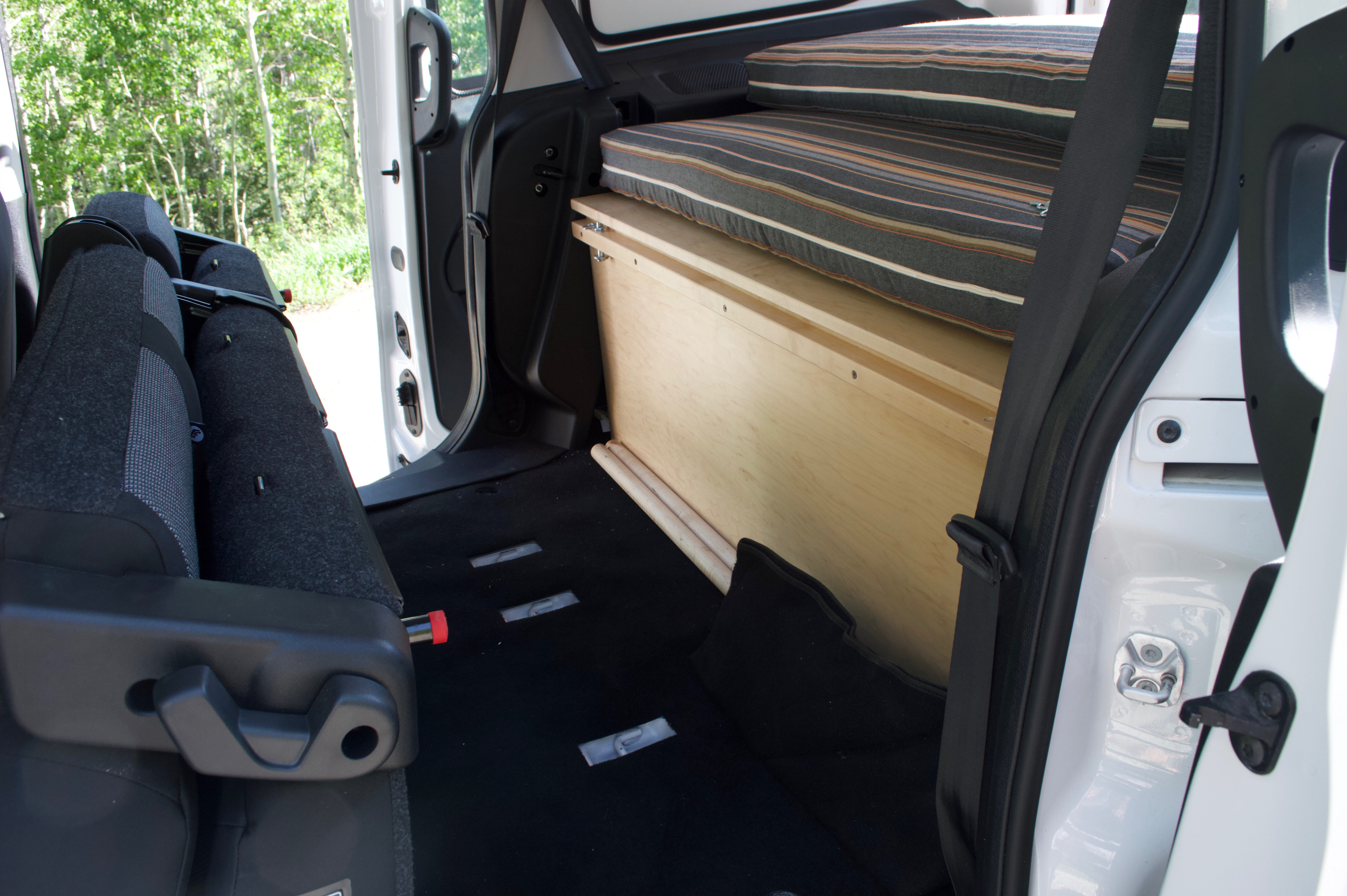 RV rental interior: A practical van conversion with a built-in bed platform and adaptable rear seating.. Ram Promaster City 2018