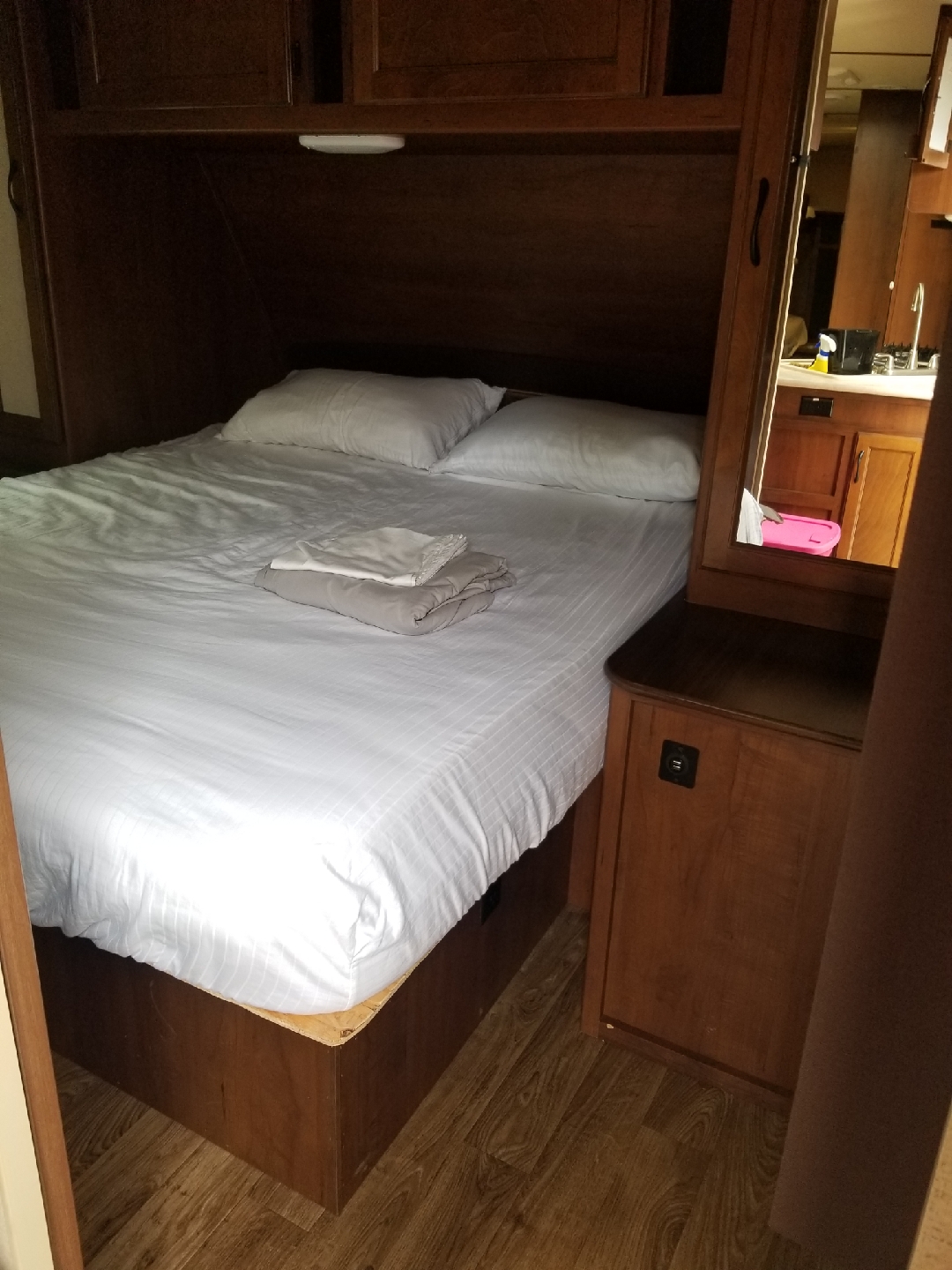 Cozy RV rental bedroom with fresh linens & a mirrored view of the kitchen, perfect for your next adventure.. Jayco White Hawk Ultra Lite 2015