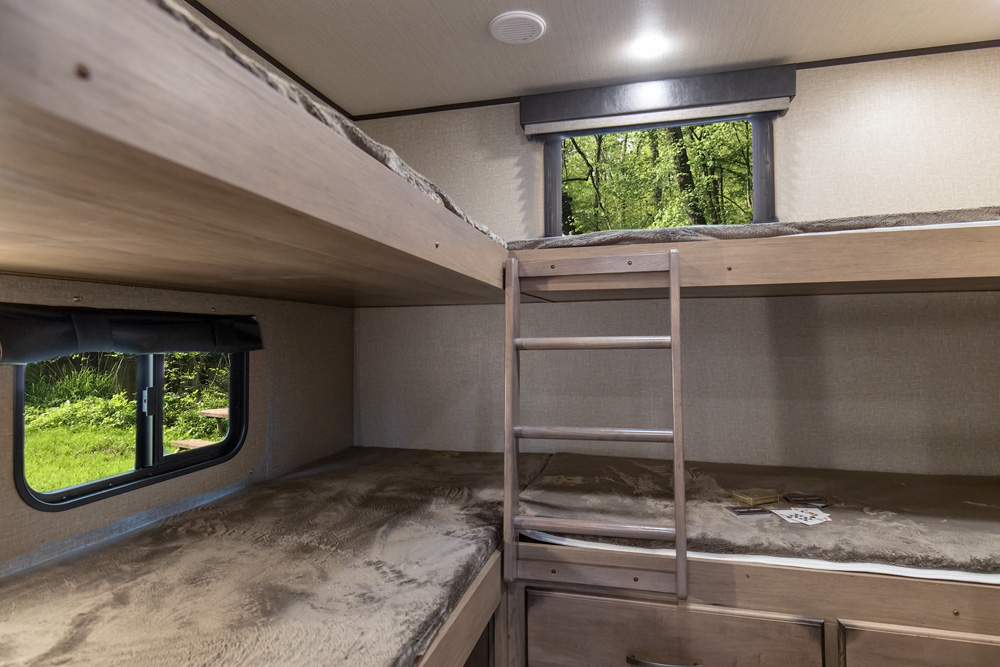 Cozy bunk beds inside an RV rental, perfect for family adventures. Enjoy camping trips with comfortable sleeping space.. Grand Design Transcend 2019