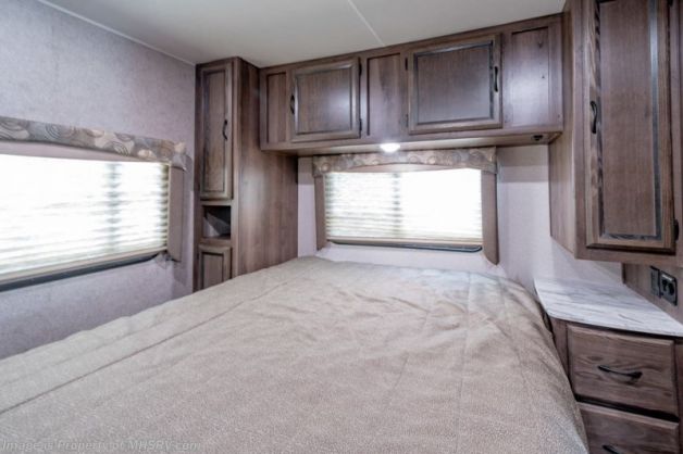 Comfortable RV rental bedroom featuring a large bed, ample storage cabinets, and a bright window.. Forest River Coachmen Freelander 2022