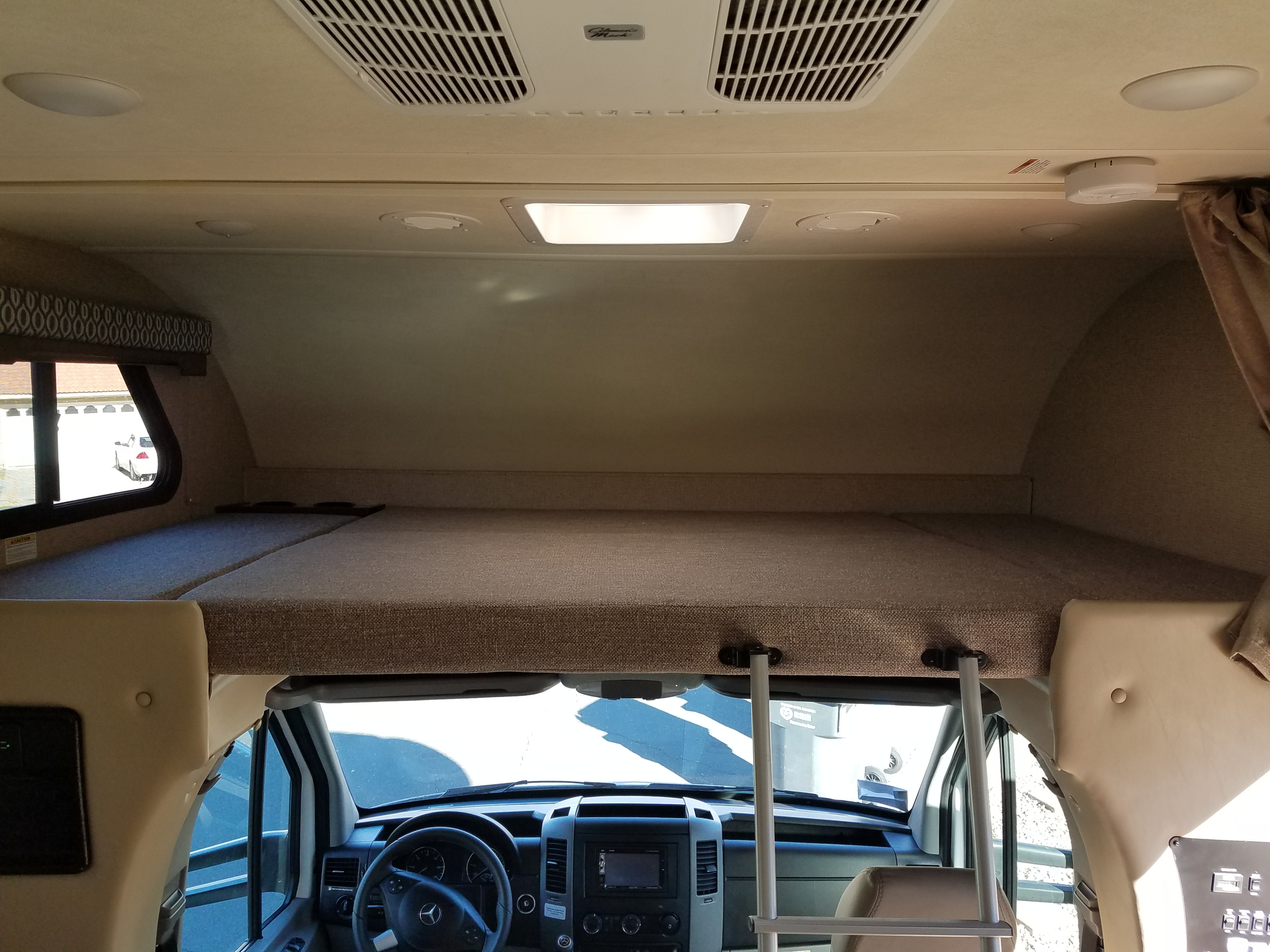 Inside an RV rental, showing the spacious overhead bunk above the driver's cockpit area.. Thor Freedom Elite 2019