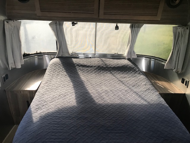 Cozy Airstream RV rental bedroom: large bed, panoramic windows, and inviting natural light. Ready for travel.. Airstream TommyBahama 2018
