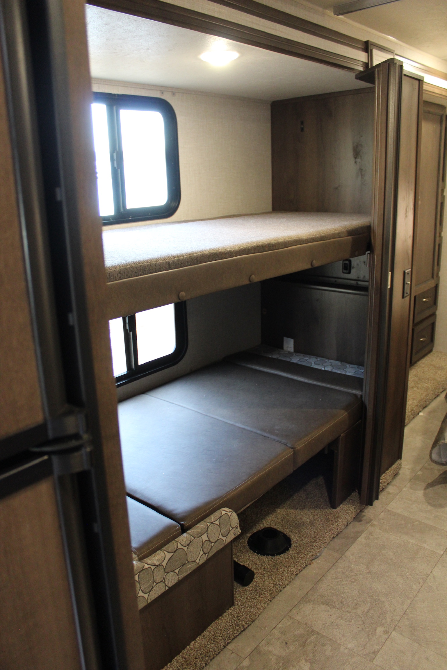 RV rental interior featuring two spacious bunk beds with windows, providing comfortable sleeping for family camping trips.. Coachmen Freelander 2019