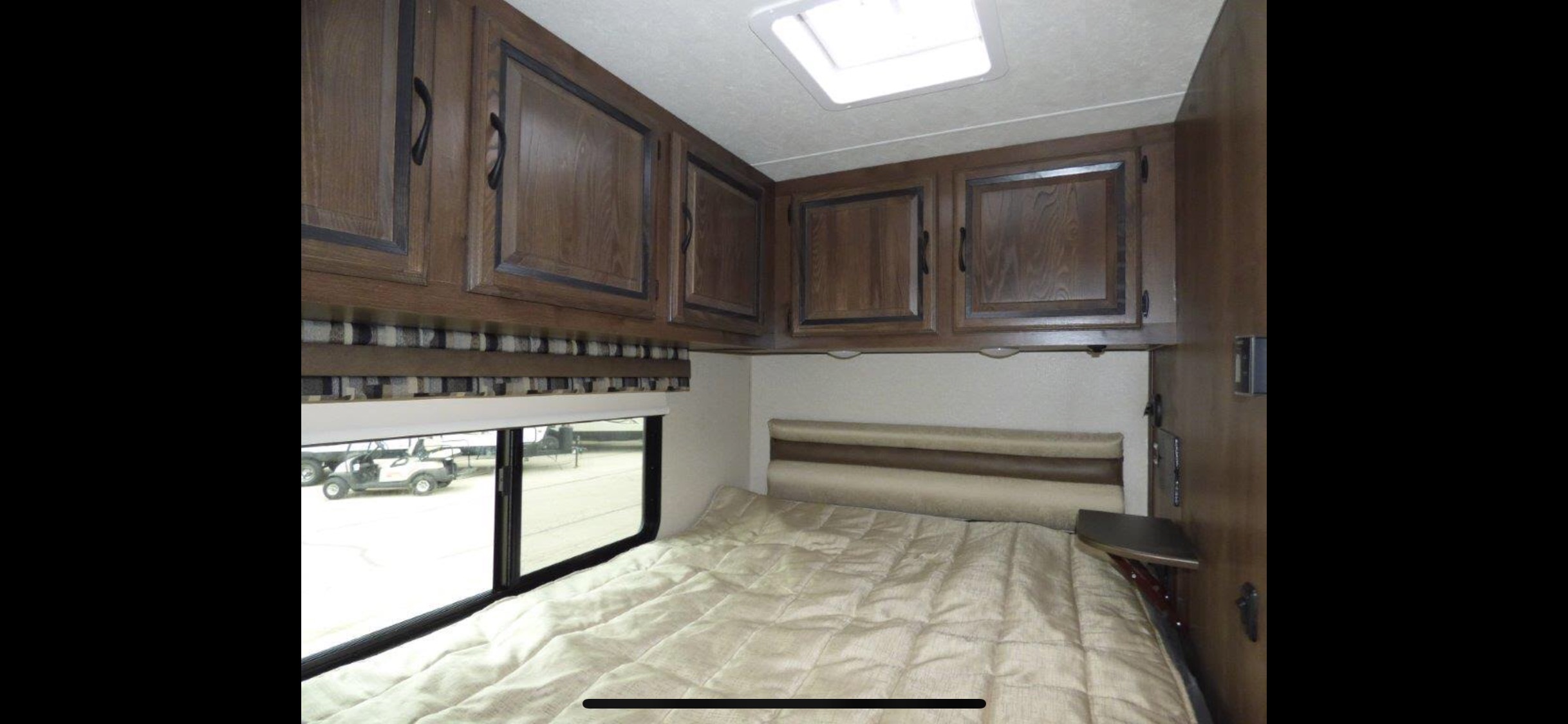 RV rental bedroom: comfortable bed, overhead cabinets, window with outdoor view, and skylight.. Other Other 2018