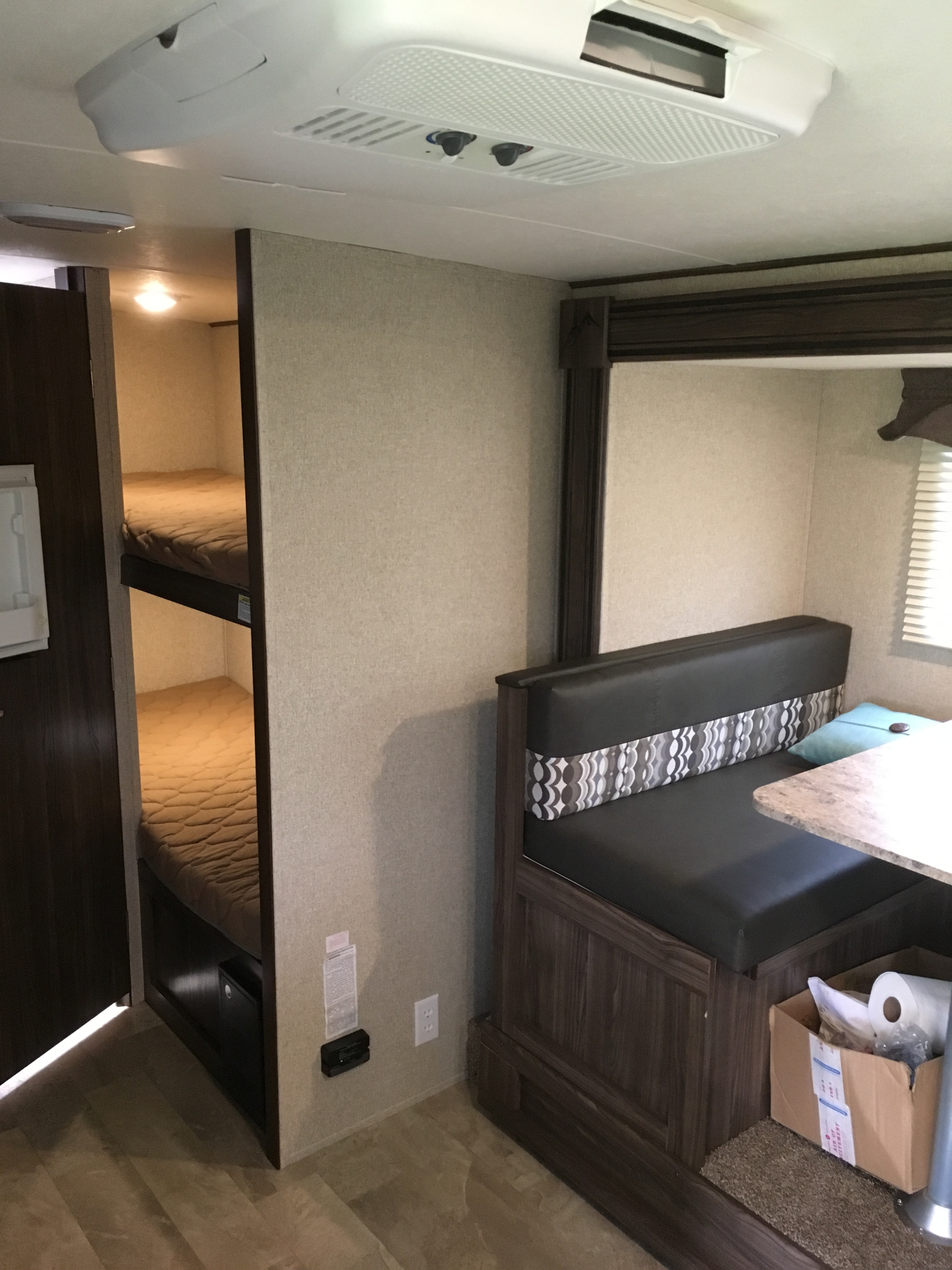Spacious RV rental interior with bunk beds, a dinette, and ceiling air conditioning, perfect for family travel.. Coachmen Apex 2018