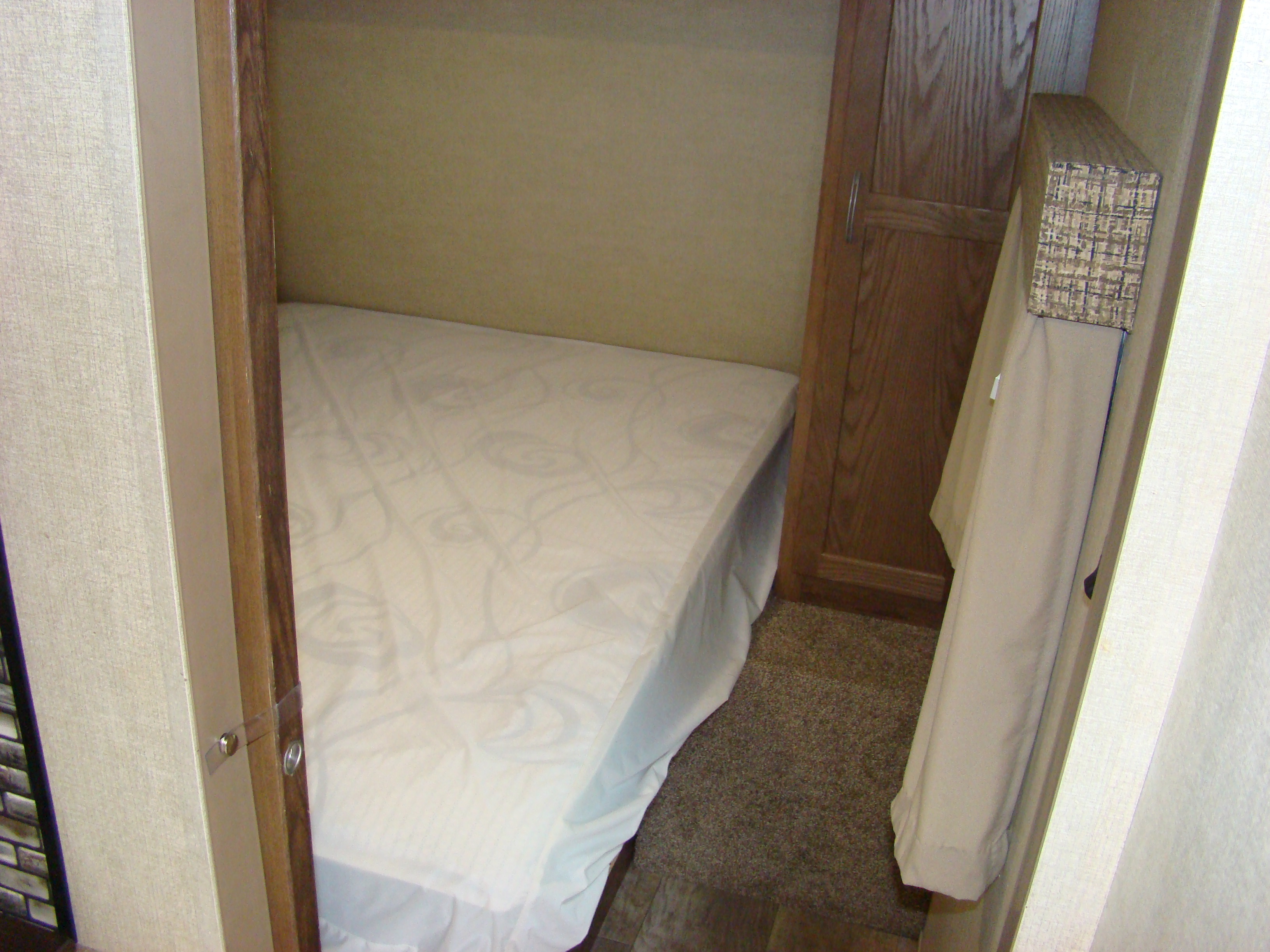 RV rental interior: cozy bedroom with a white bed, built-in wooden wardrobe, and handy hanging storage.. Conquest 275FBG 2020