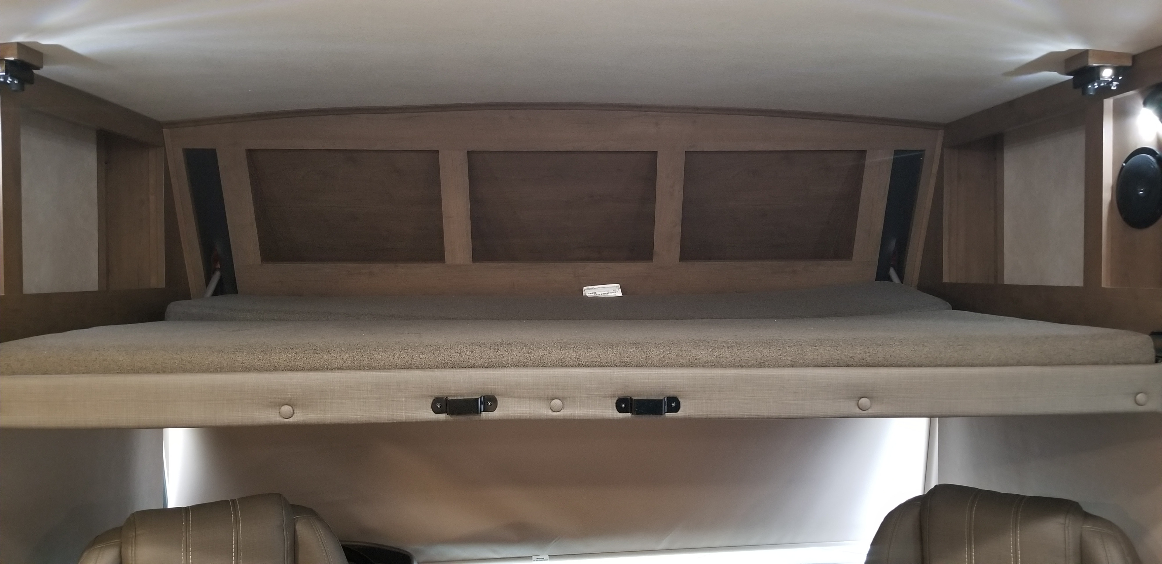 Explore a cozy RV rental's cab-over bunk. This well-lit sleeping area offers built-in storage and comfort for travel.. Forest River Fr3 2021