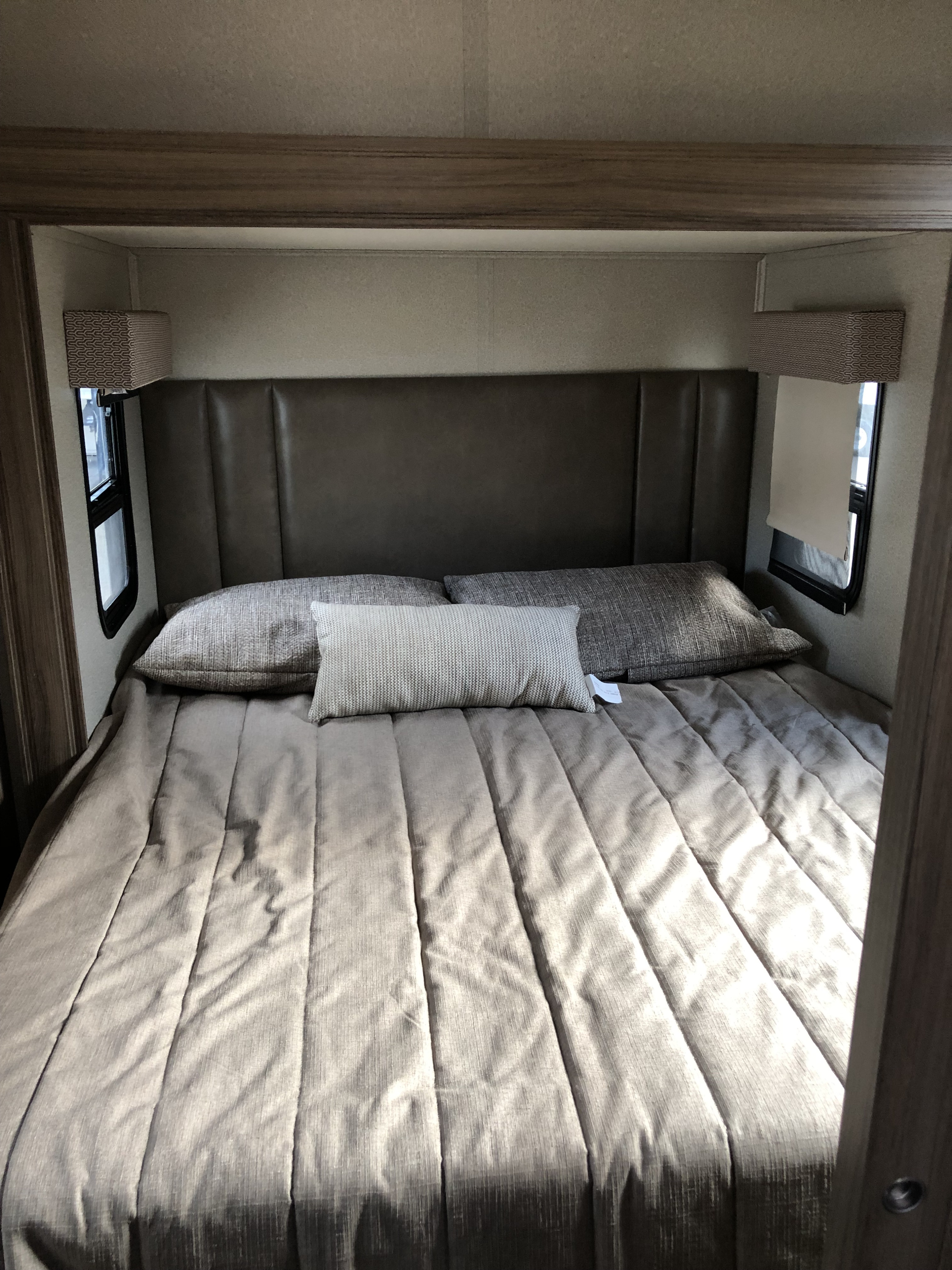 Cozy RV rental bedroom with a comfortable bed, padded headboard, and windows, perfect for restful nights.. Jayco Melbourne 2019
