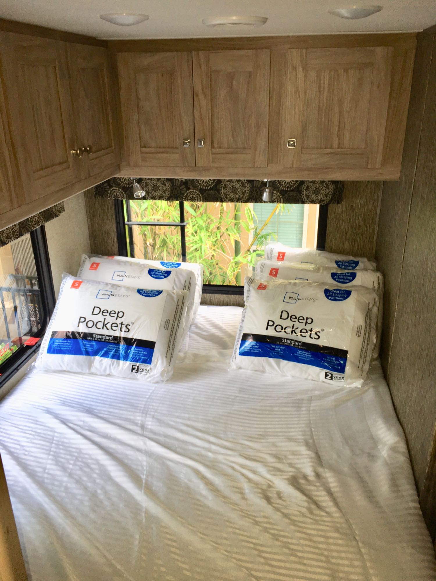 New Mainstays Deep Pockets pillows on a neatly made bed inside an RV rental, ready for guests.. ForestRiver Sunseeker 2018