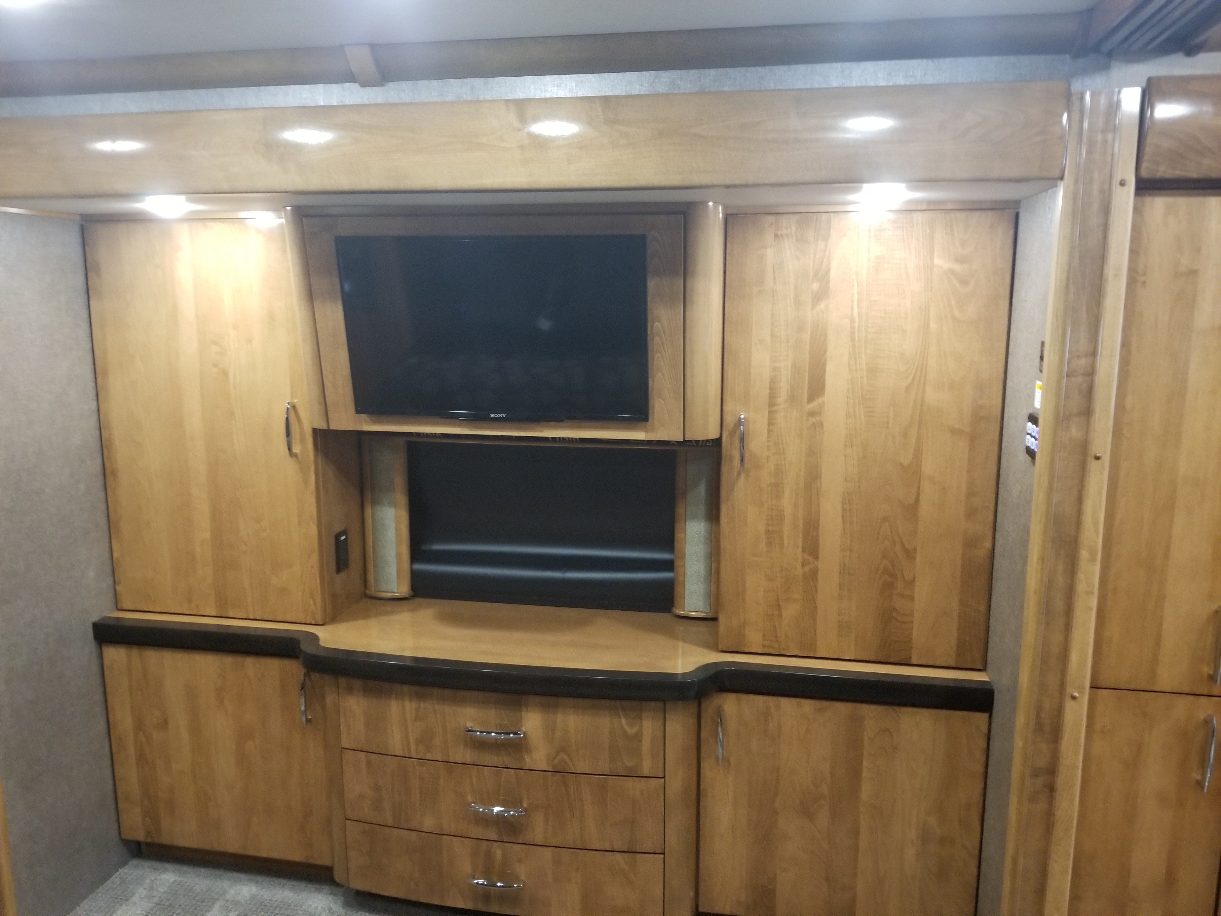 This RV rental features a built-in wood entertainment unit with a flat-screen TV, ample storage cabinets, and drawers.. Fleetwood American Eagle 2019