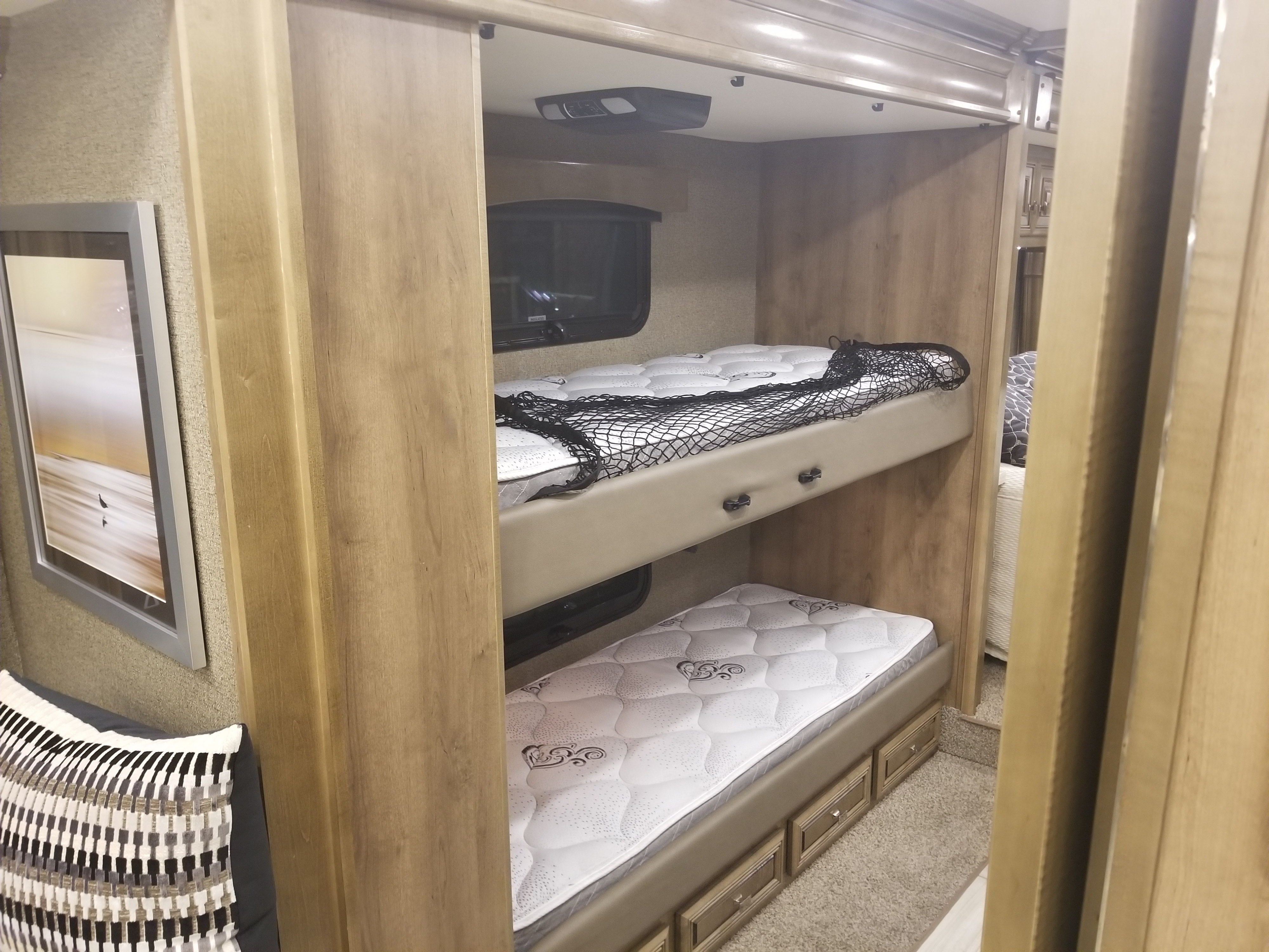 Cozy RV rental interior featuring two comfortable bunk beds with safety net and storage, ideal for family adventures.. Fleetwood Discovery 2019