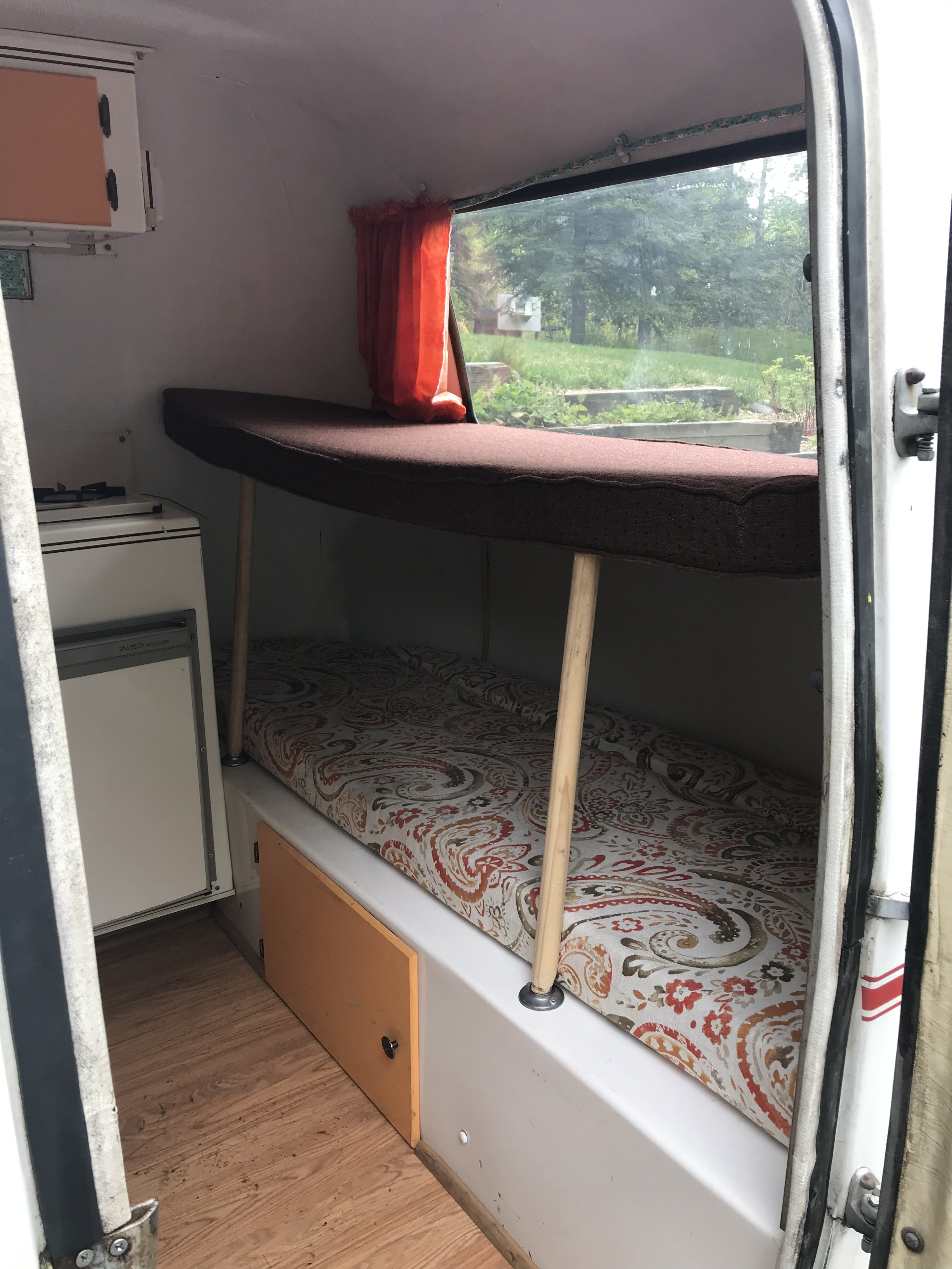 Inside this RV rental: bunk beds, compact kitchen with stove and fridge. Cozy camper interior.. Scamp 13' 1987
