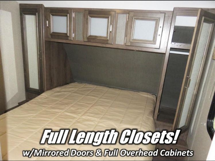 Spacious RV rental bedroom with mirrored full-length closets and overhead cabinets for ample storage.. Keystone RV Passport Grand Touring 2018