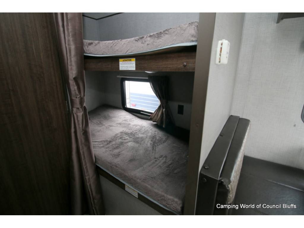 RV rental: interior featuring two compact bunk beds with a privacy curtain and window, next to a seating area.. Crossroads Zinger 2020