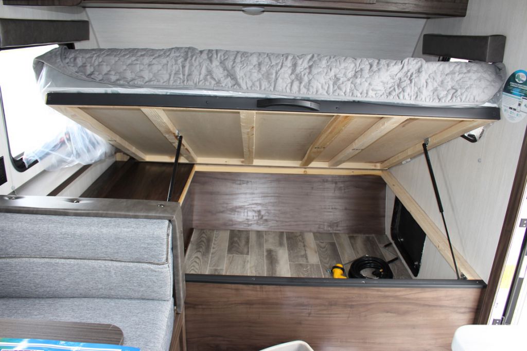 An RV rental's clever design: a lifted bed mattress reveals generous under-bed storage with a durable floor.. Forest River Cherokee Wolf Pup 2019