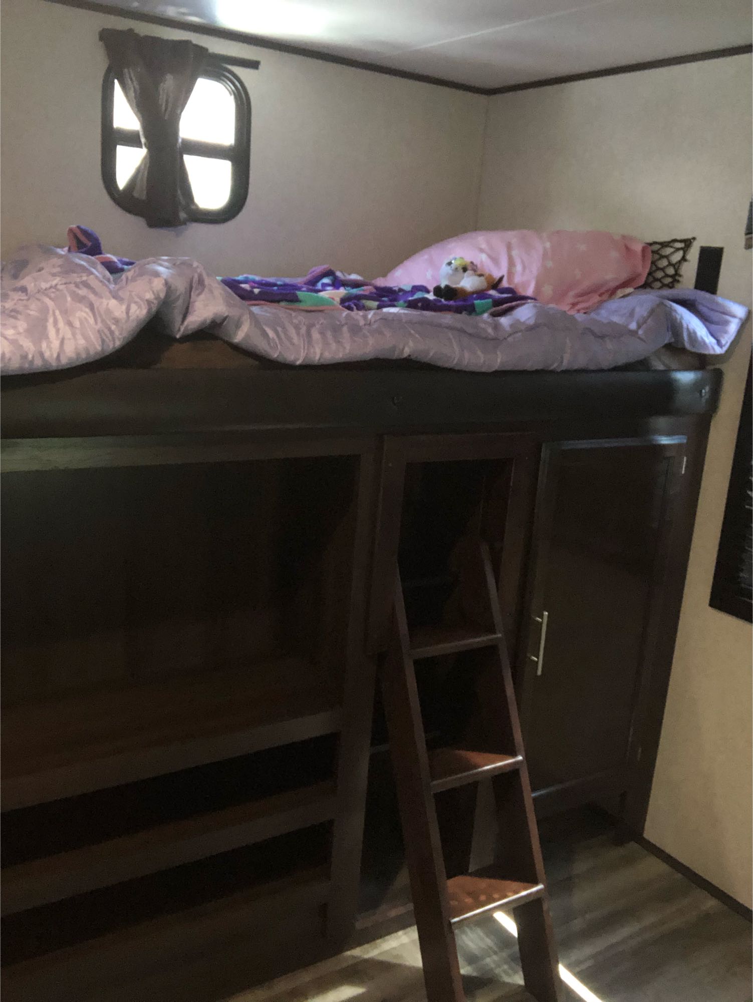 Cozy RV rental bunk bed with ladder and storage. Features a comfy top bunk and compact interior window.. Jayco Other 2020