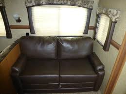 RV rental: See this comfy brown sofa & windows with blinds inside a travel trailer. Perfect for relaxing during your trip.. Crossroads Sunset Trail Reserve 2014