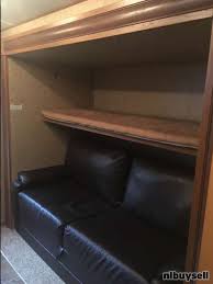 Ideal RV rental interior: a dark leather-look sofa beneath a bunk bed, offering versatile seating and sleeping arrangements.. Crossroads Sunset Trail Reserve 2014