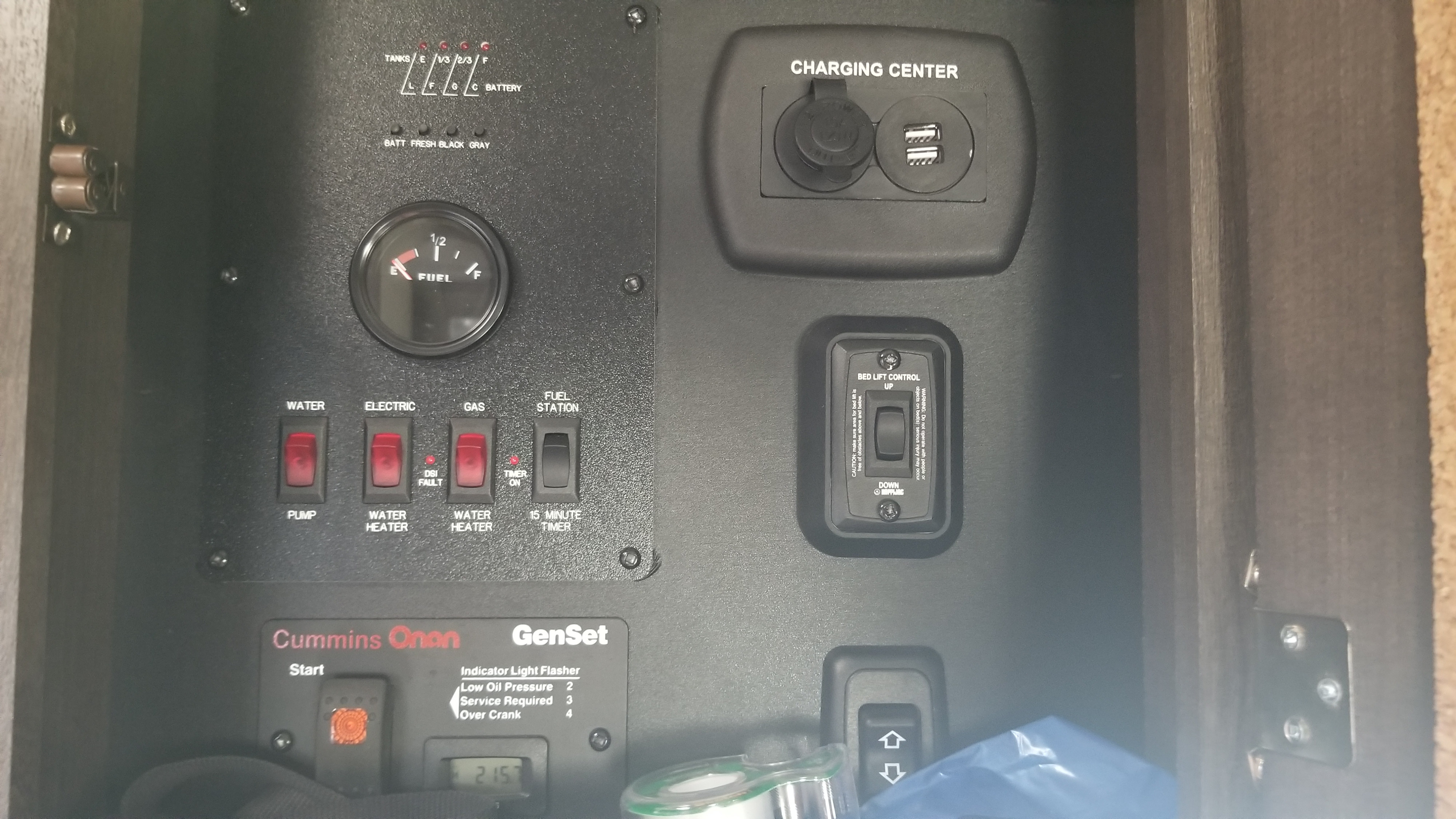 This RV rental's control panel features tank levels, fuel gauge, water/generator switches, charging center, and bed lift controls.. Forest River Stealth 2018