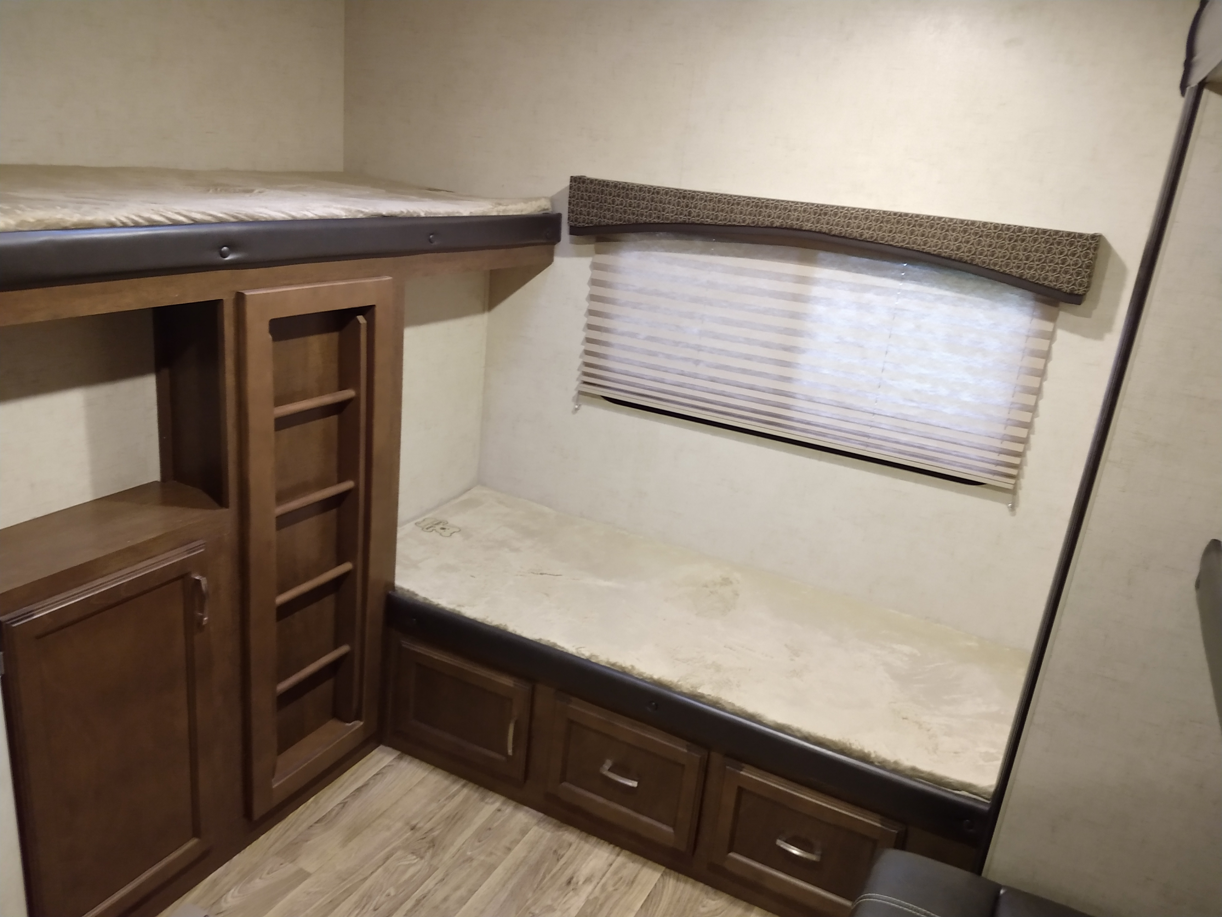 RV rental interior featuring comfortable bunk beds, built-in storage, and a window with blinds.. Venture Sporttrek 2017