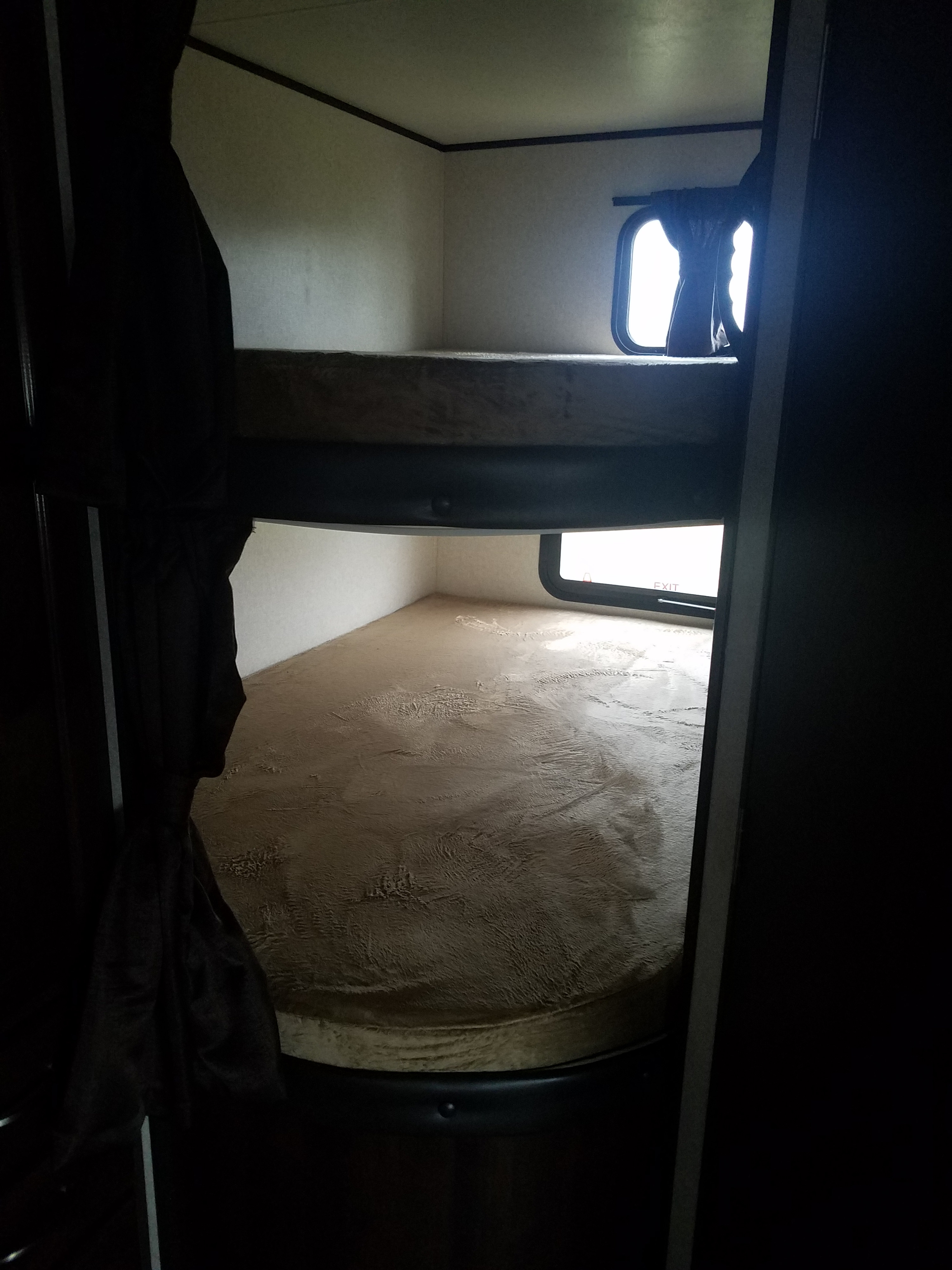 This RV rental features stacked bunk beds with windows, providing compact and cozy sleeping arrangements inside the vehicle.. Jayco Jay Flight 2018