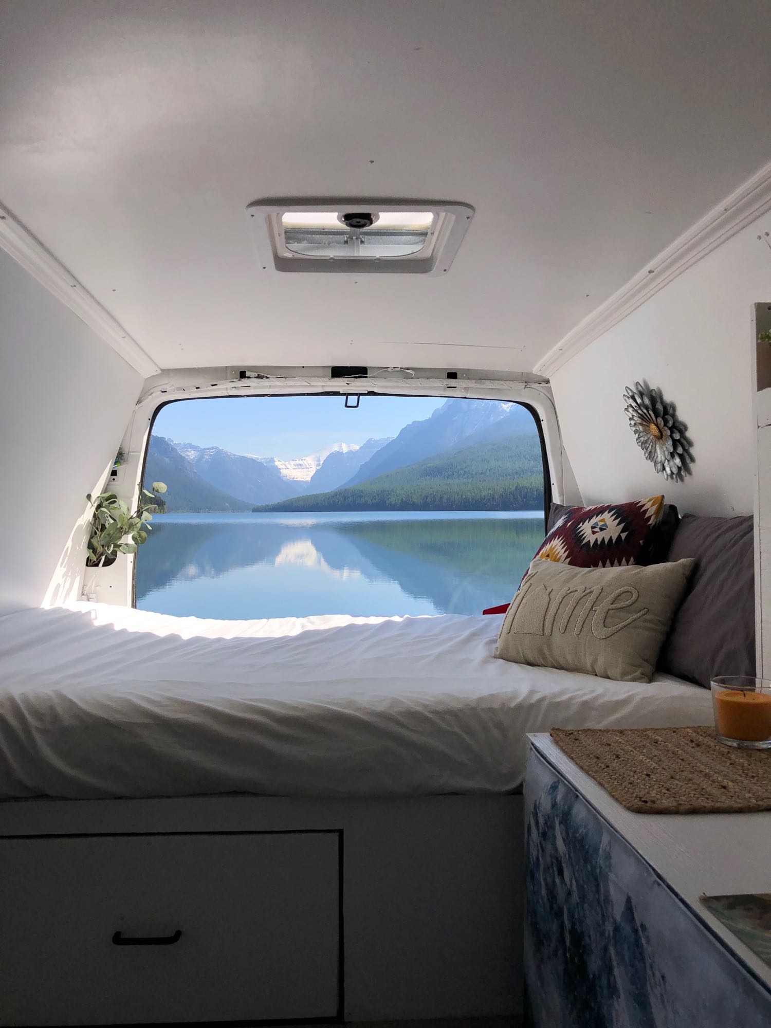 RV rental comfort: Cozy camper bed with a spectacular mountain lake view. Embrace adventure in this serene camper van!. Chevrolet Express 1500 2006