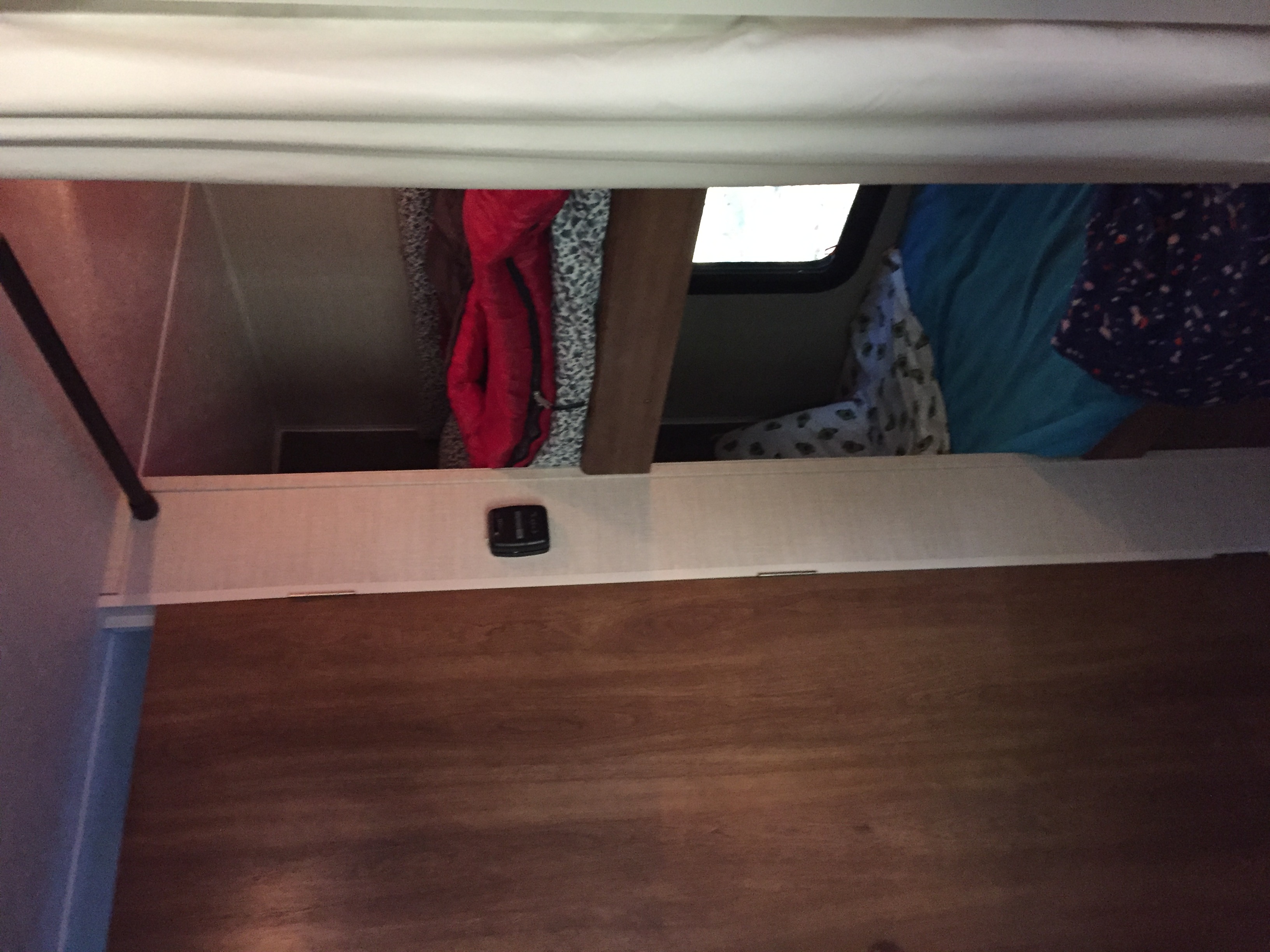**RV rental**: Inside, a compact bunk bed area features blue bedding, clothing, a window, and a small device.. Keystone RV Summerland Mini 2015