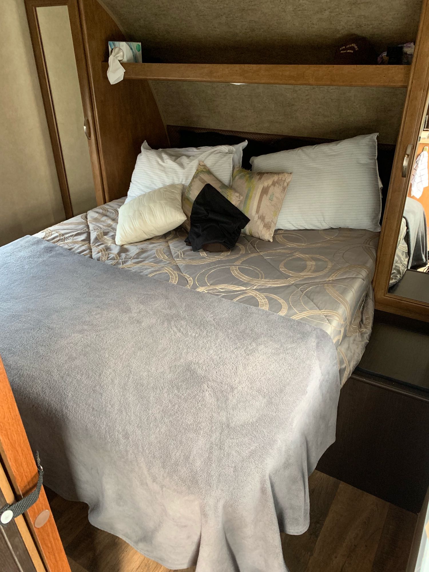 Cozy RV rental bedroom with a comfy bed, pillows, and overhead storage for a restful trip.. Forest River Wildwood 2017