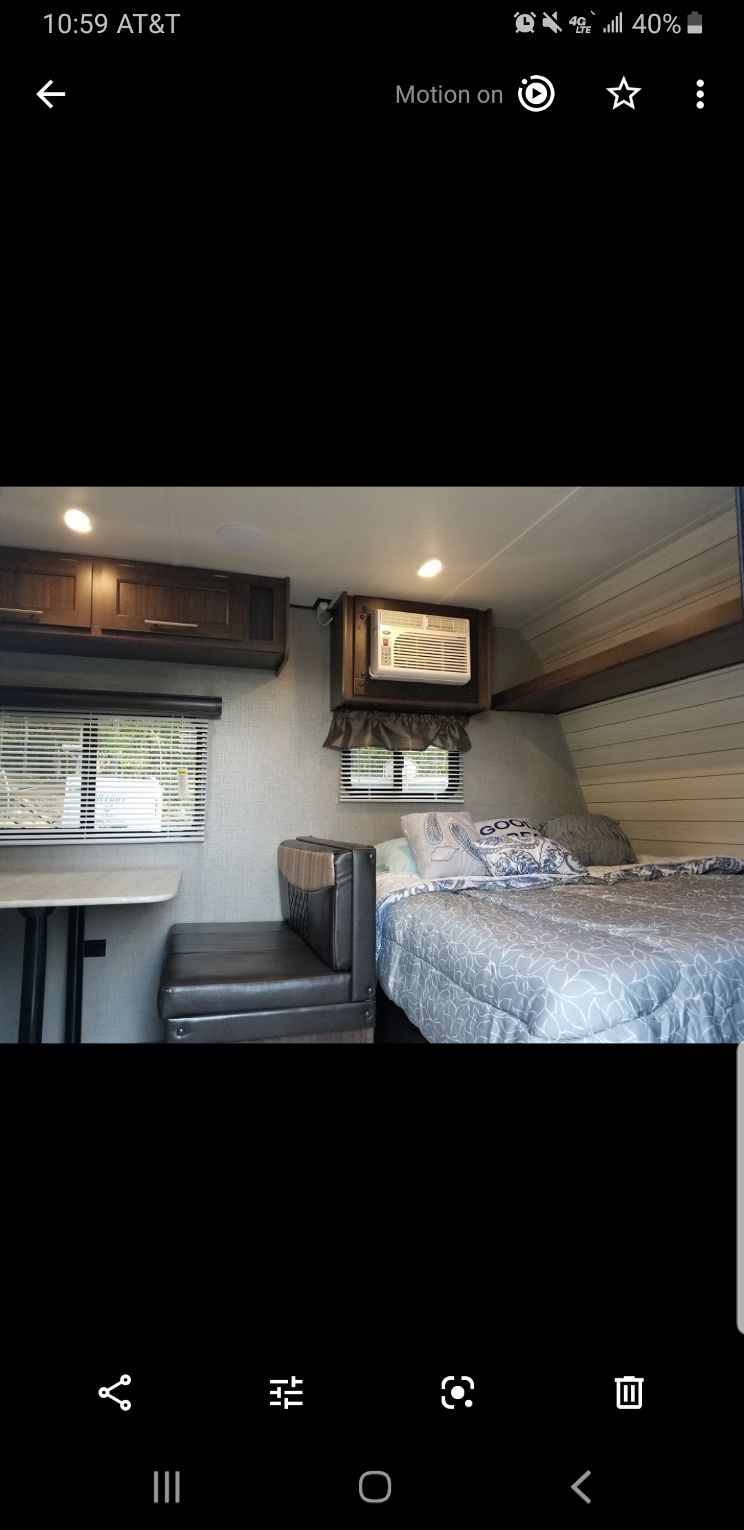 Cozy RV rental interior with a comfortable bed, dinette, and a window air conditioner unit mounted above for cooling.. Crossroads RV Zinger Lite 2019