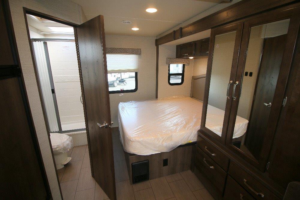 Inside this RV rental: a bright, modern bedroom with a queen bed and mirrored wardrobe, connected to a private bathroom.. Jayco Melbourne 2019